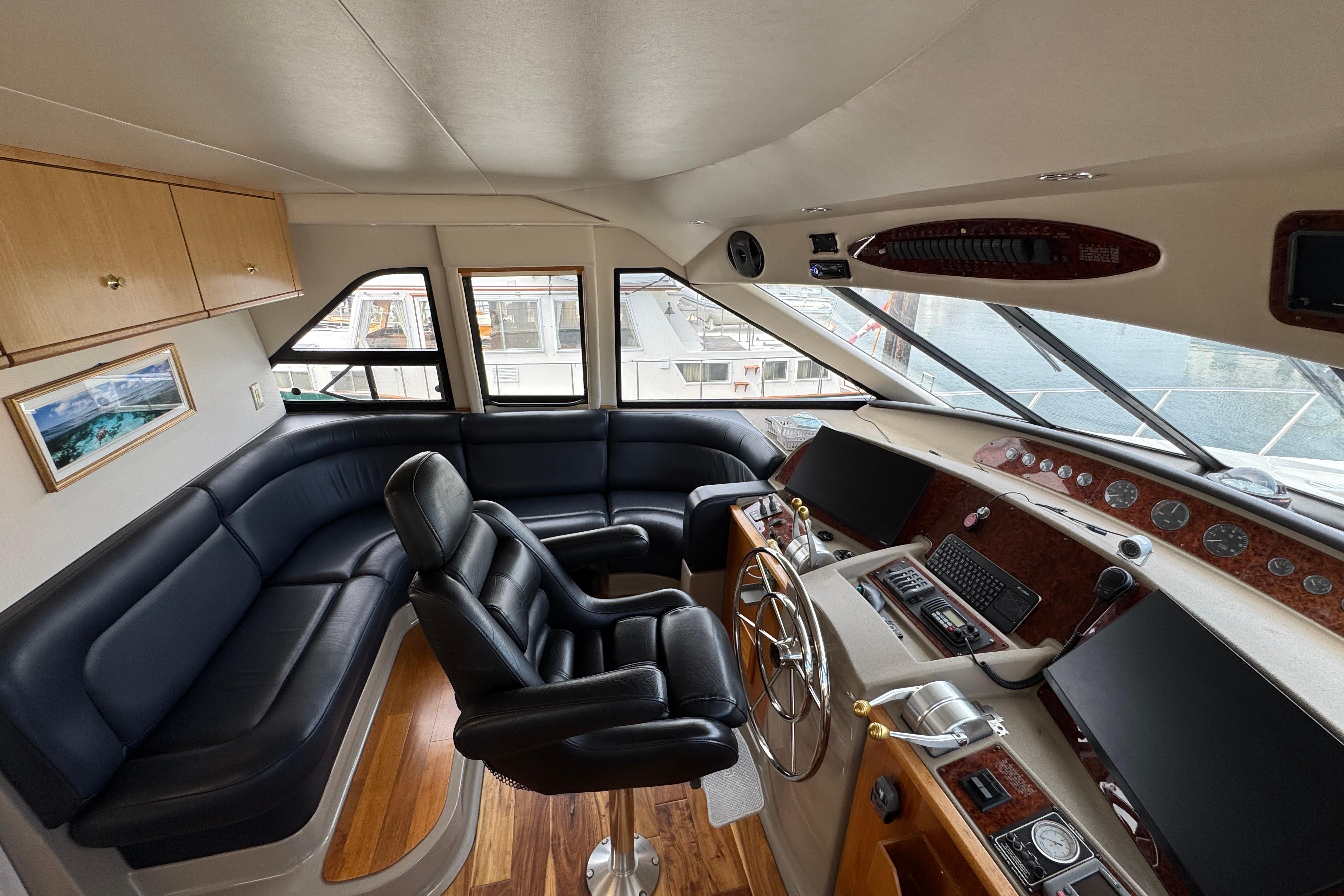 Luxurious 1998 Bayliner 5788 Pilot House Motoryacht interior with leather seating and navigation controls.