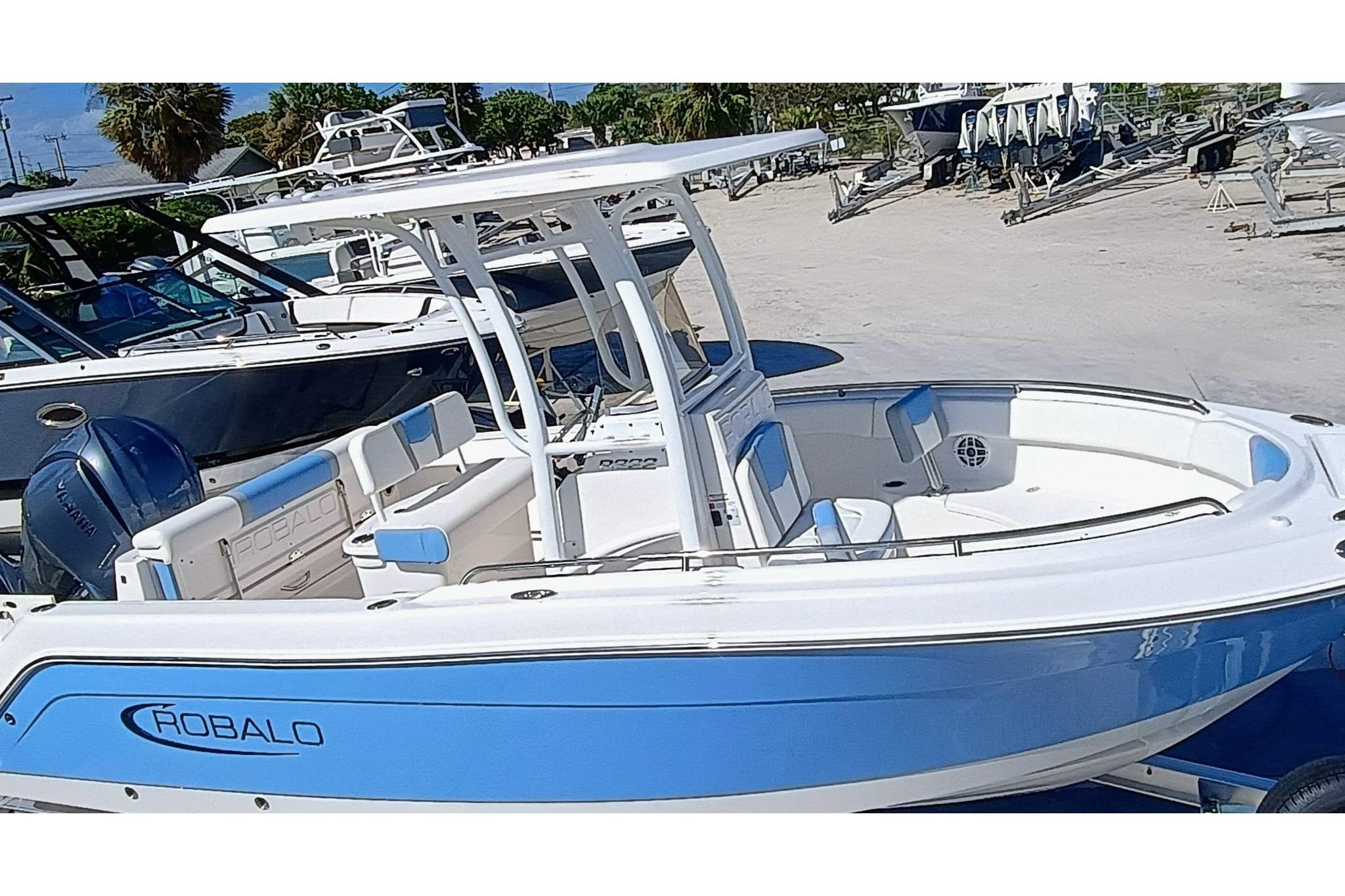 2025 Robalo R222 Center Console boat in blue and white, docked outdoors.