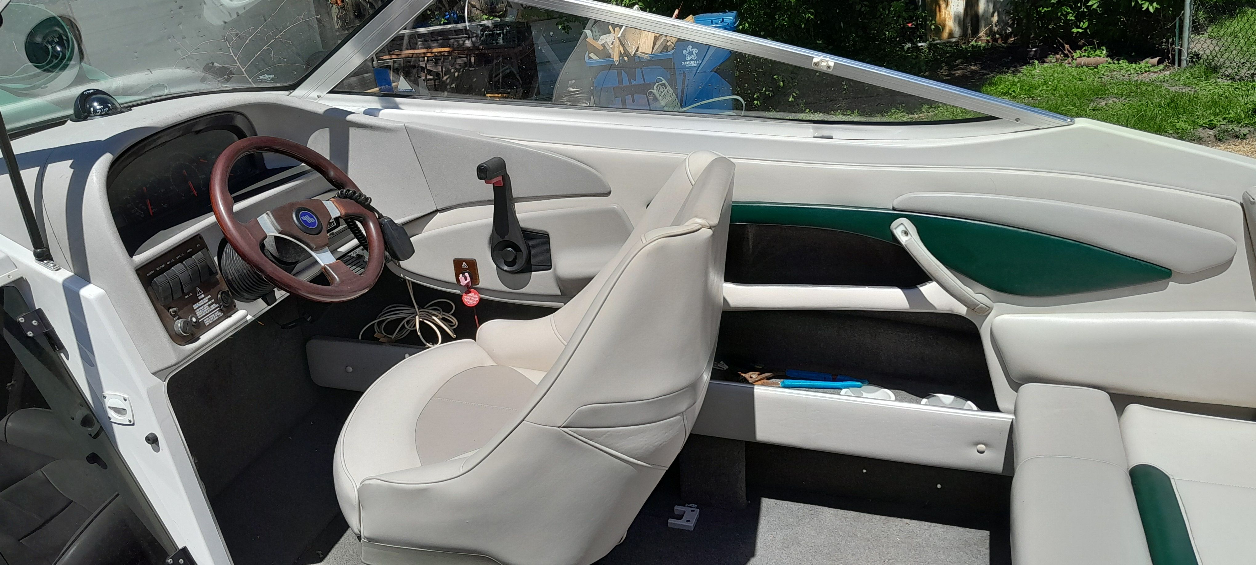Interior of a 1995 Four Winns 205 Sundowner boat with steering wheel and seats.