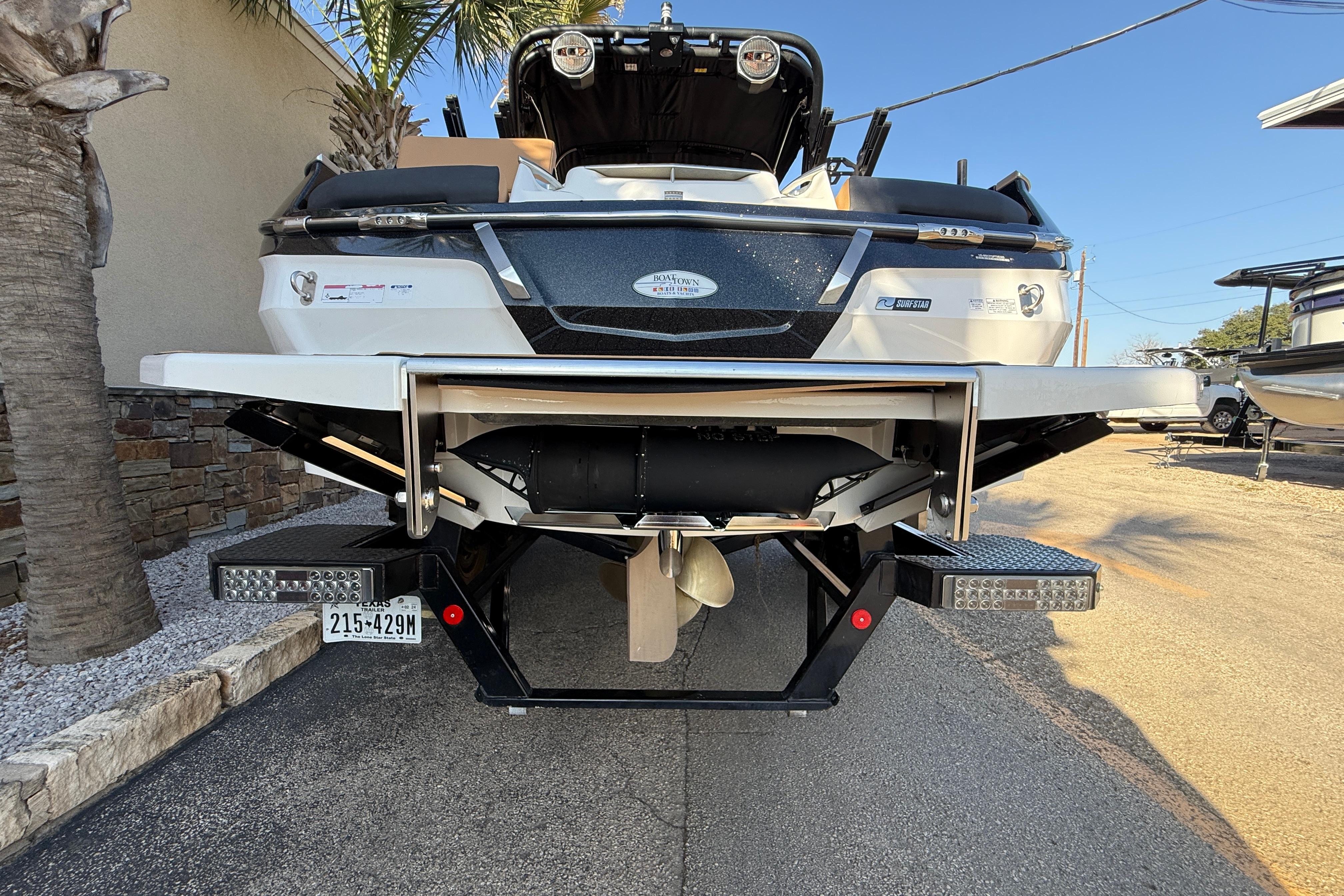 2023 MasterCraft X22 boat rear view with trailer, parked outdoors.