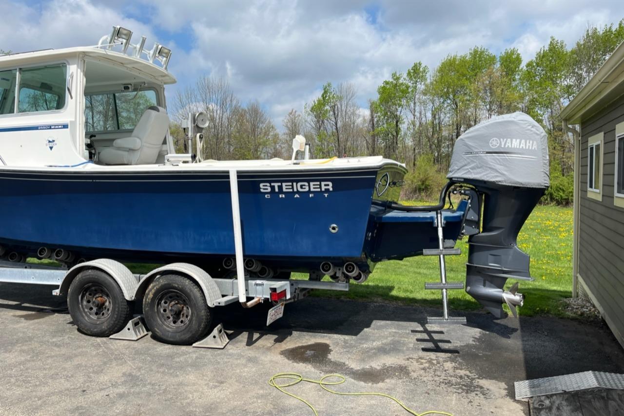 2012 Steiger Craft Miami boat on trailer with Yamaha engine cover, parked outdoors.