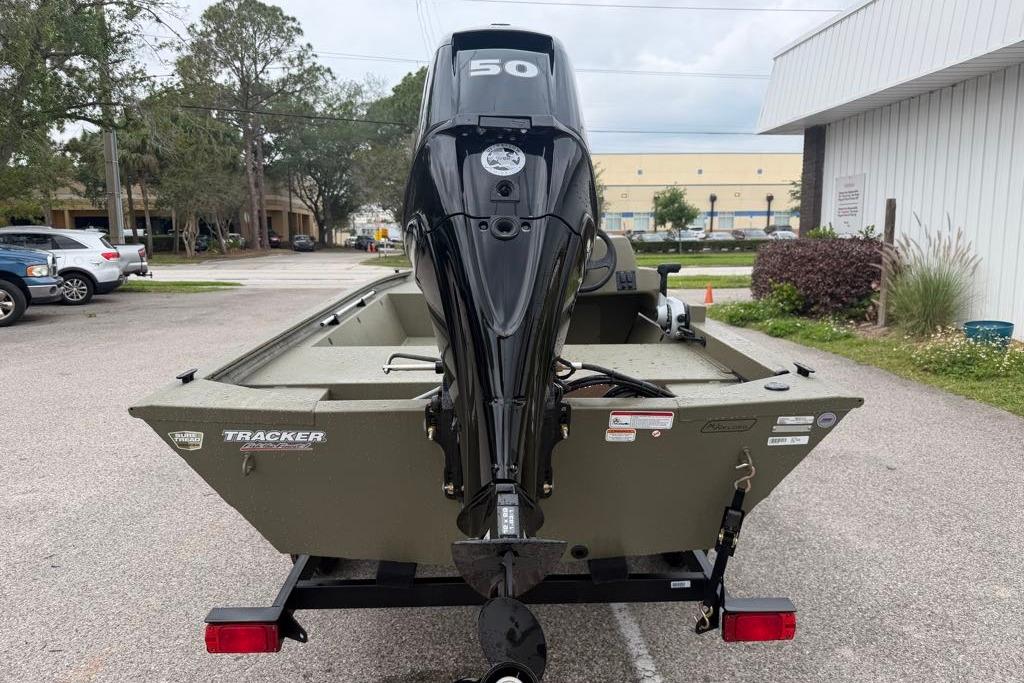2026 Tracker Grizzly 1648 SC boat with powerful outboard motor in a parking lot.