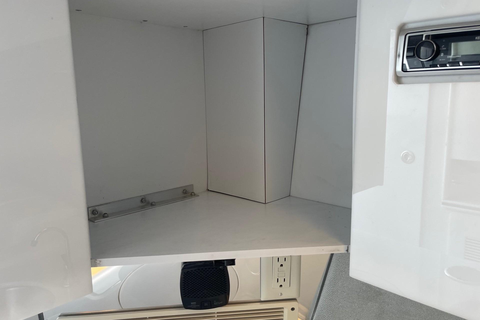 2004 Formula 382 FASTech interior cabinet with stereo system and power outlet.