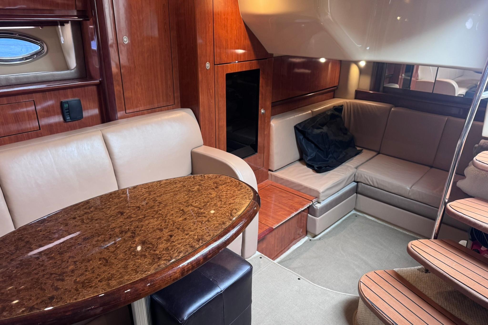 Luxurious interior of 2004 Sea Ray 390 Sundancer yacht with elegant seating and wooden finishes.