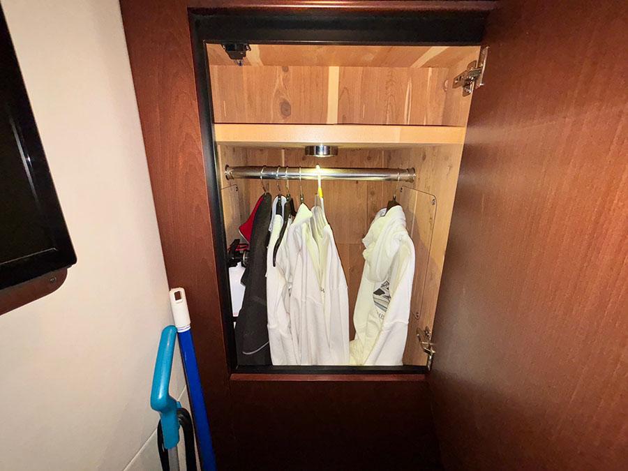 Closet interior on 2013 Sea Ray 450 Sedan Bridge with hanging clothes and cleaning tools.