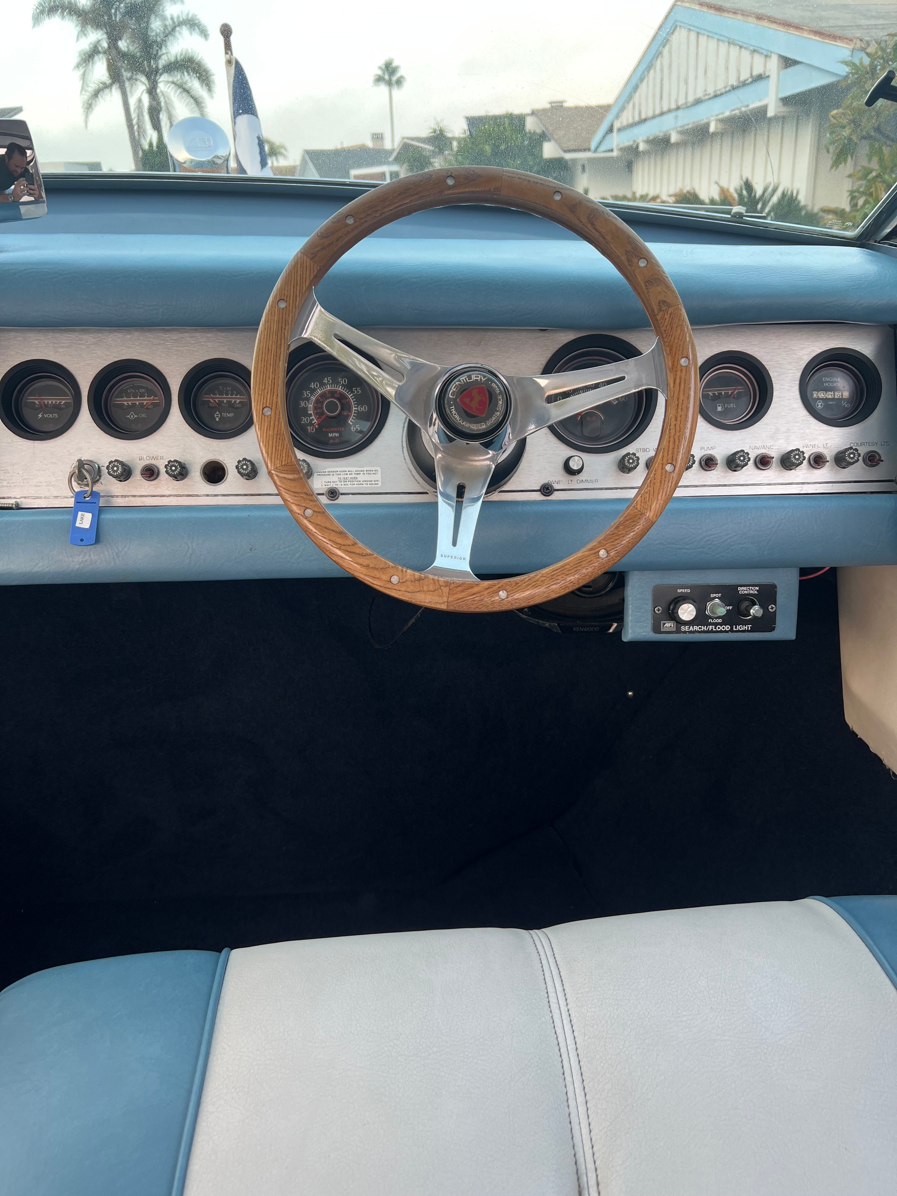 1985 Century Coronado Cardel dashboard with wooden steering wheel and vintage gauges.