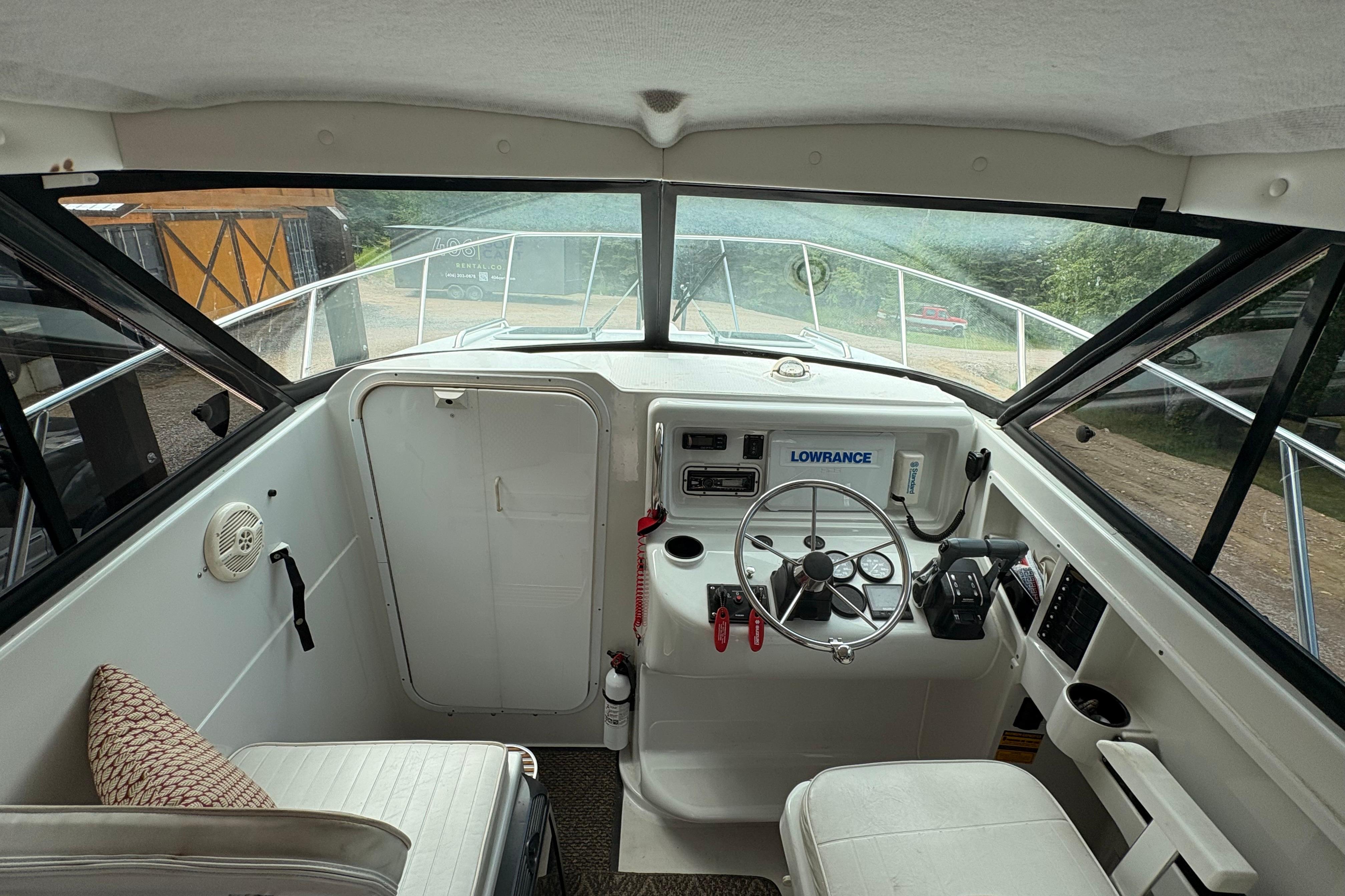 Interior view of 2001 Glacier Bay 2690 Coastal Runner boat cockpit with steering wheel and controls.