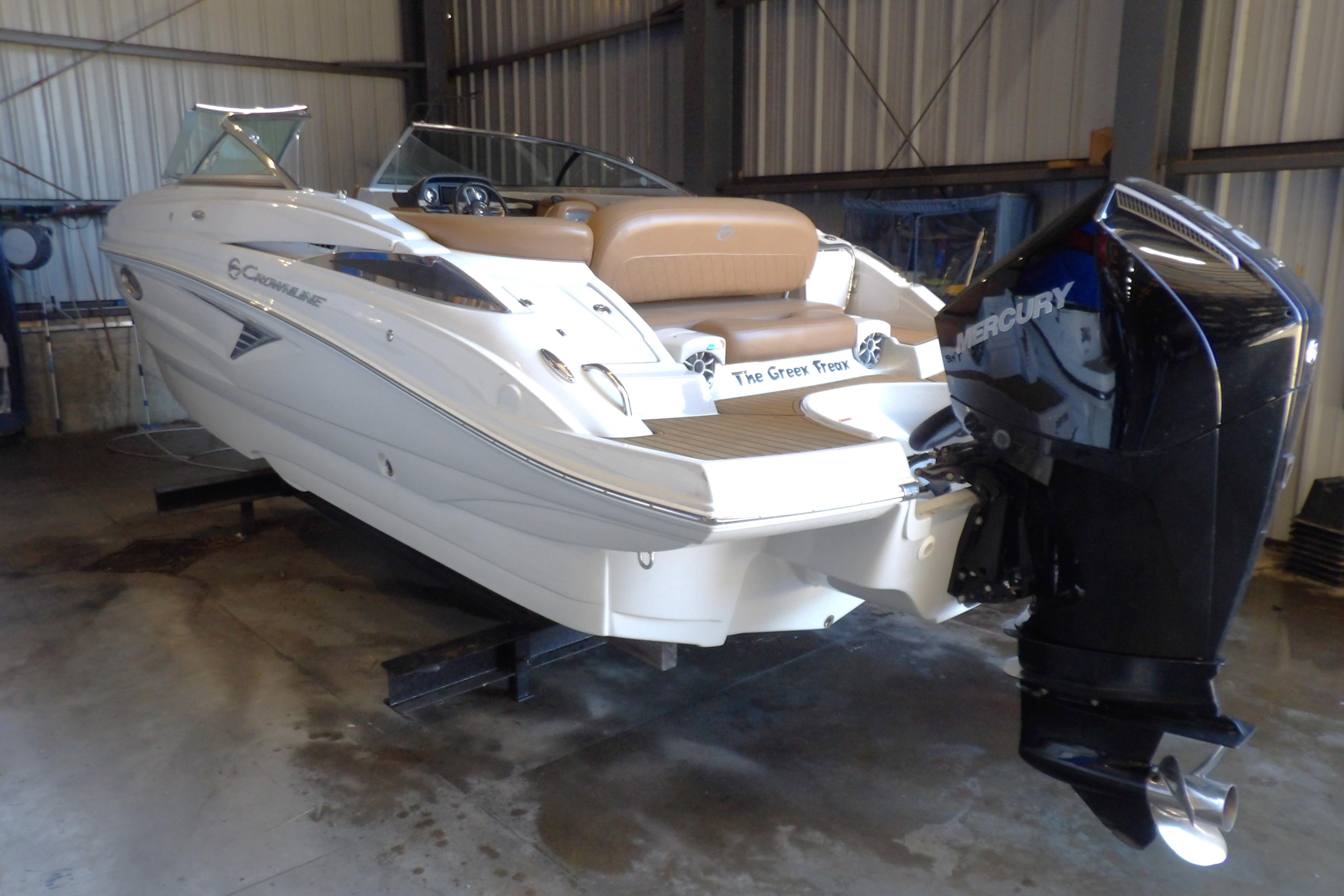 2023 Crownline 250 XSS boat with Mercury engine in a storage facility.