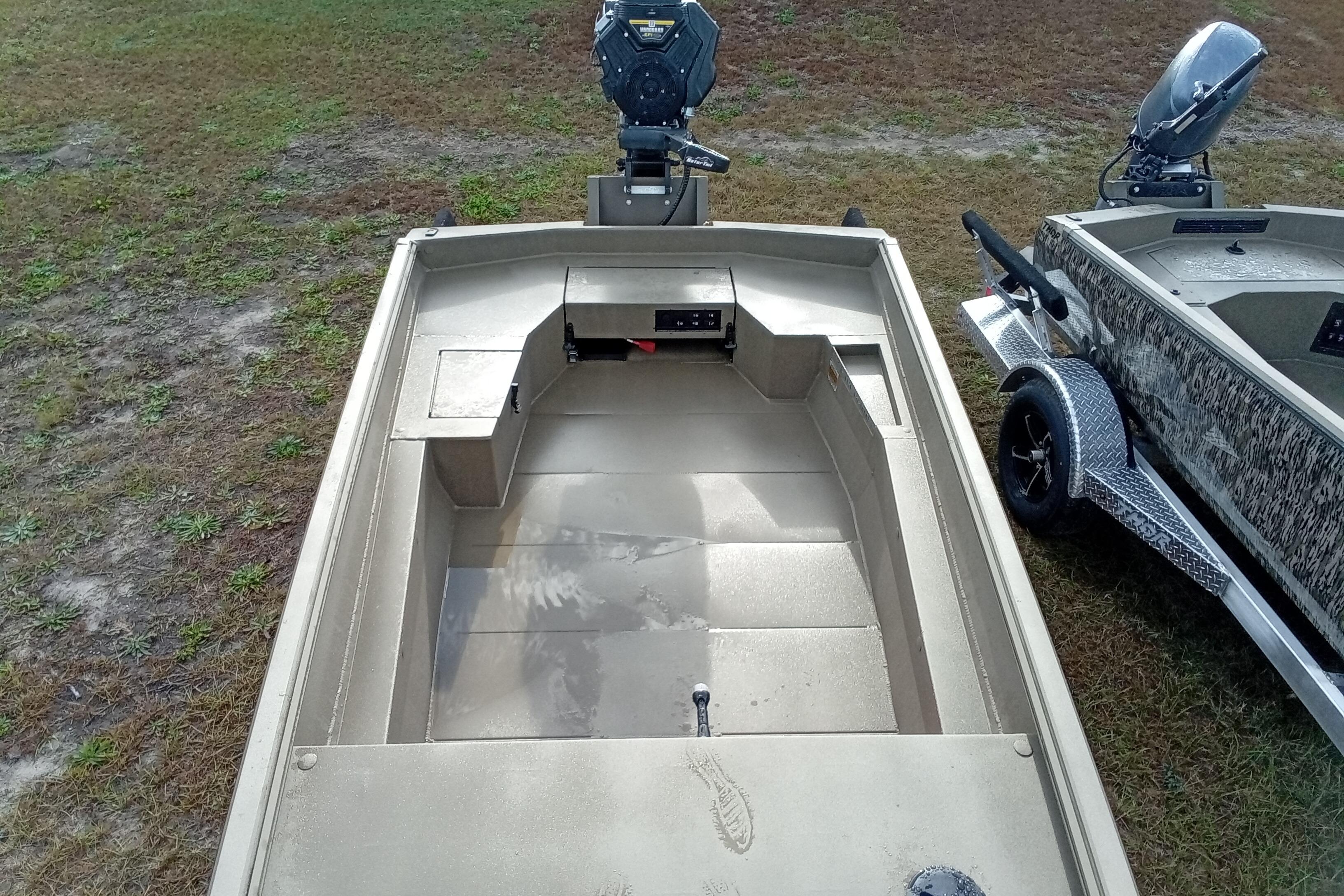 2026 Thor 1754 Swamp Hammer boat on grass, featuring open deck and motor.