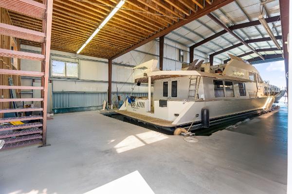 1985 Custom Larson Boathouse with boat docked inside spacious indoor marina.