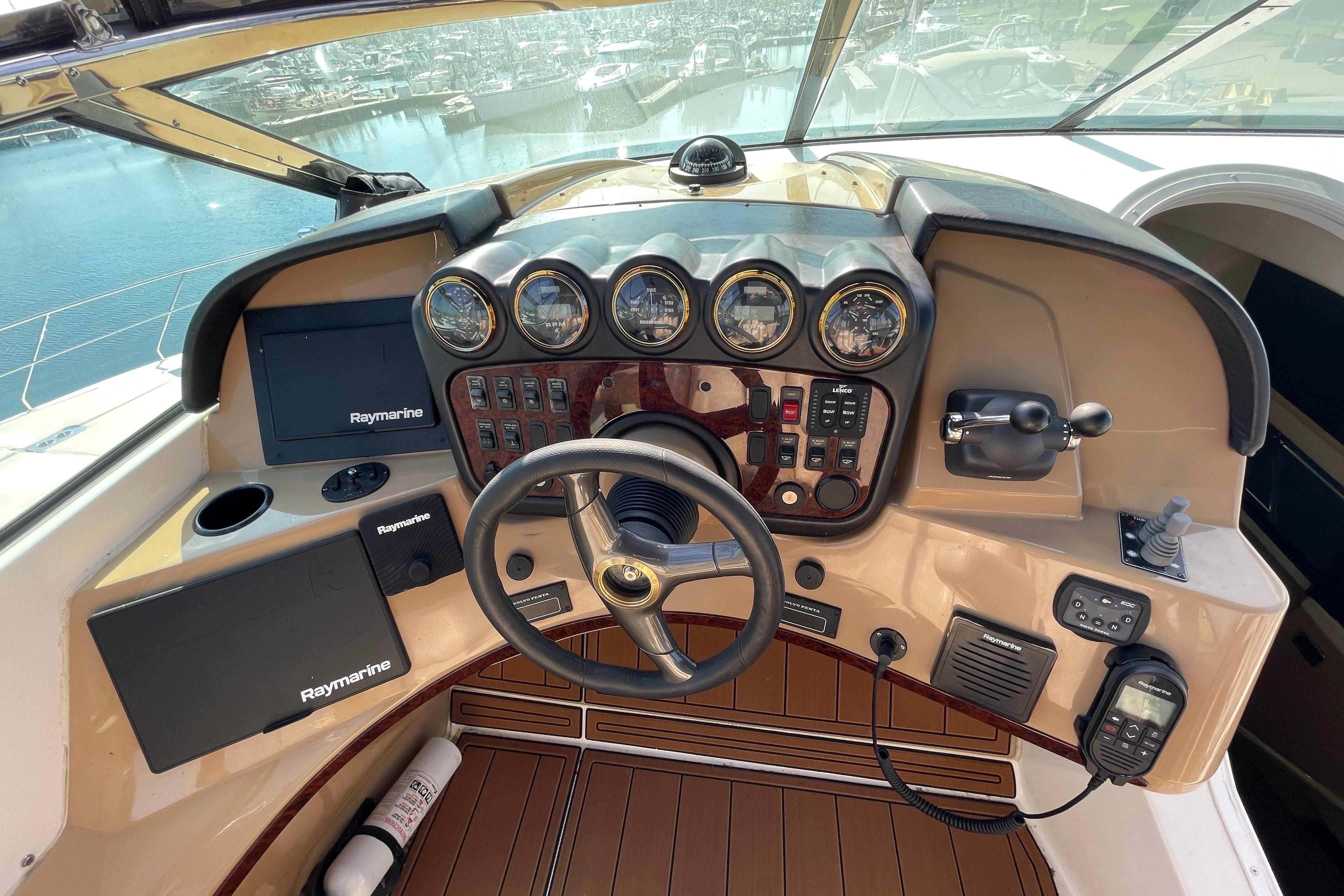 2002 Carver 570 Voyager Pilothouse helm with Raymarine navigation, steering wheel, and control panel.