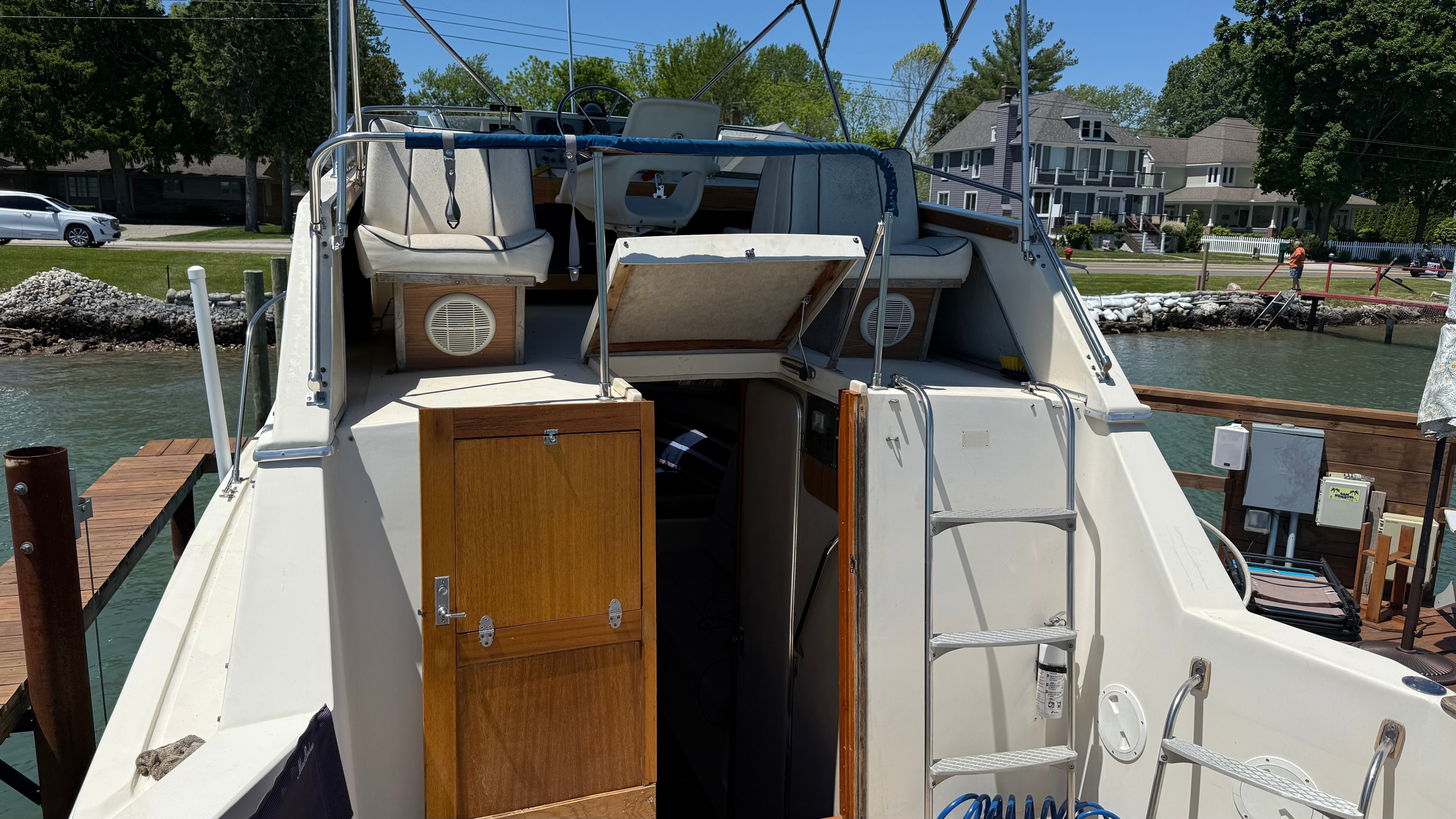 A Chris-Craft 292 Catalina Sunbridge boat docked with an open cabin and ladders.