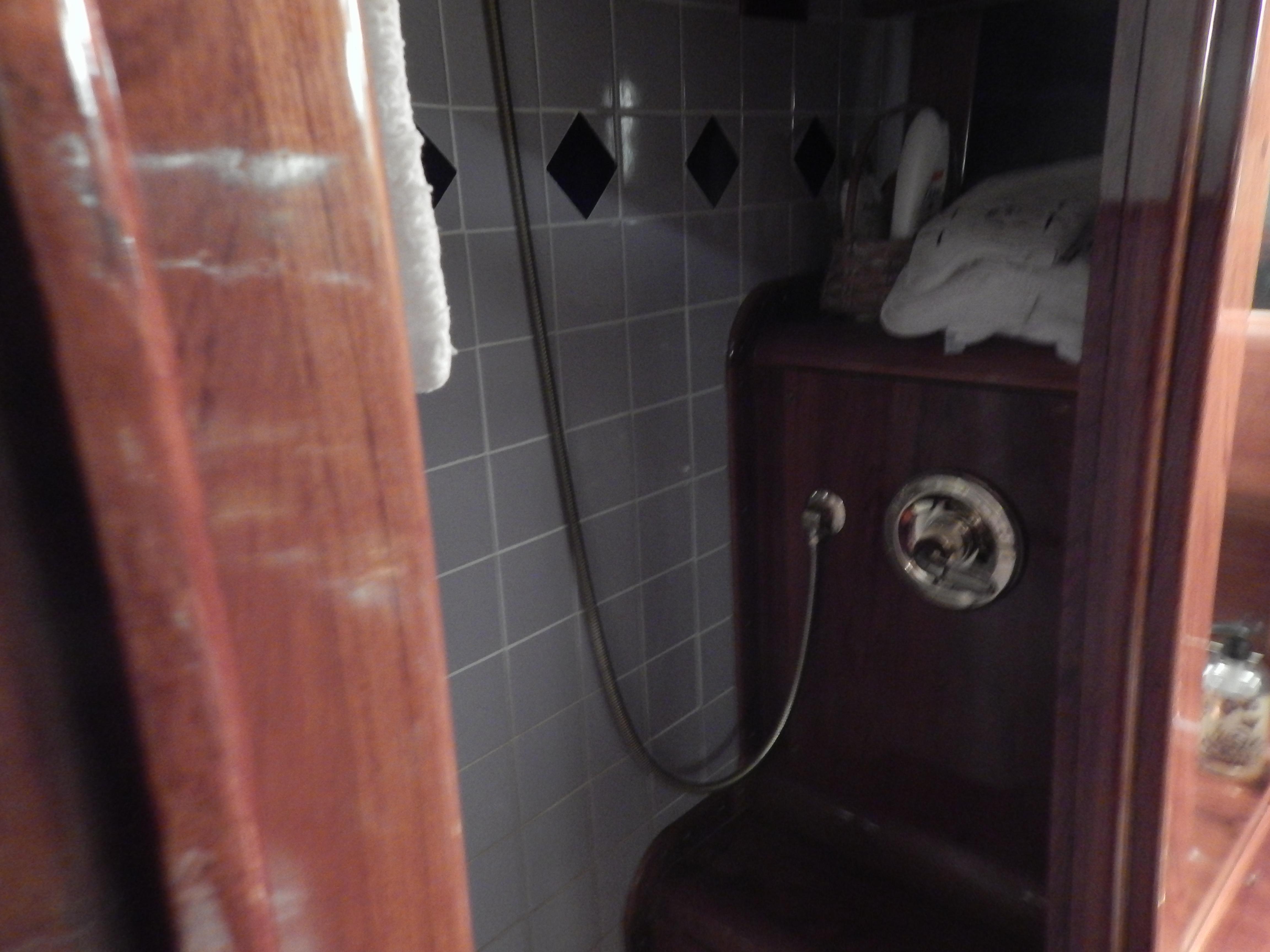 1974 Pacemaker Cockpit Motoryacht bathroom with wooden accents and tiled walls.