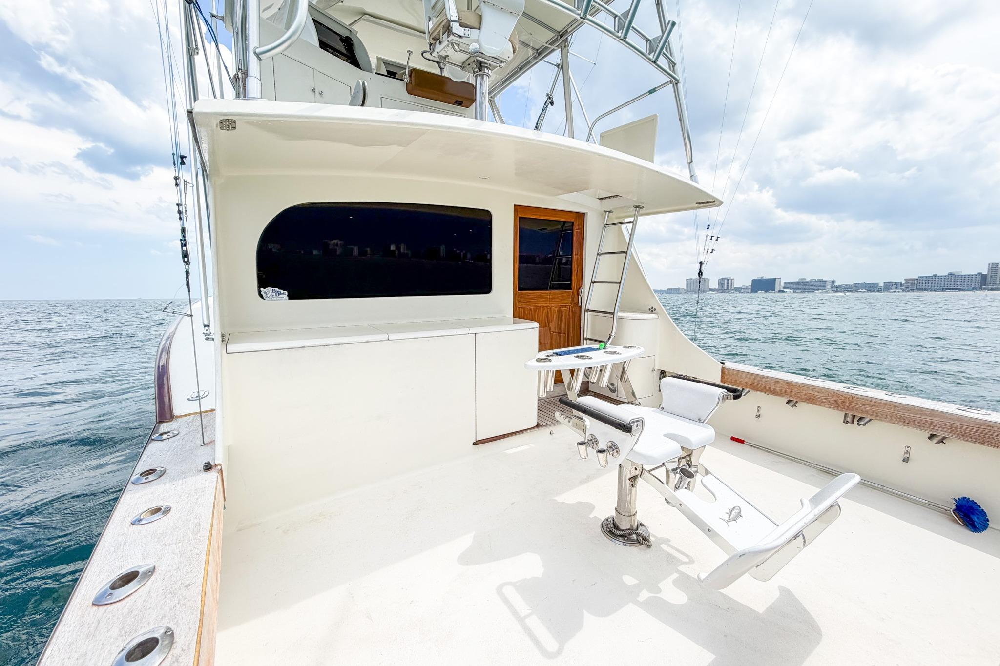 1998 Blackwell Custom Carolina Sportfish boat deck with fishing chair, ocean view, and city skyline.