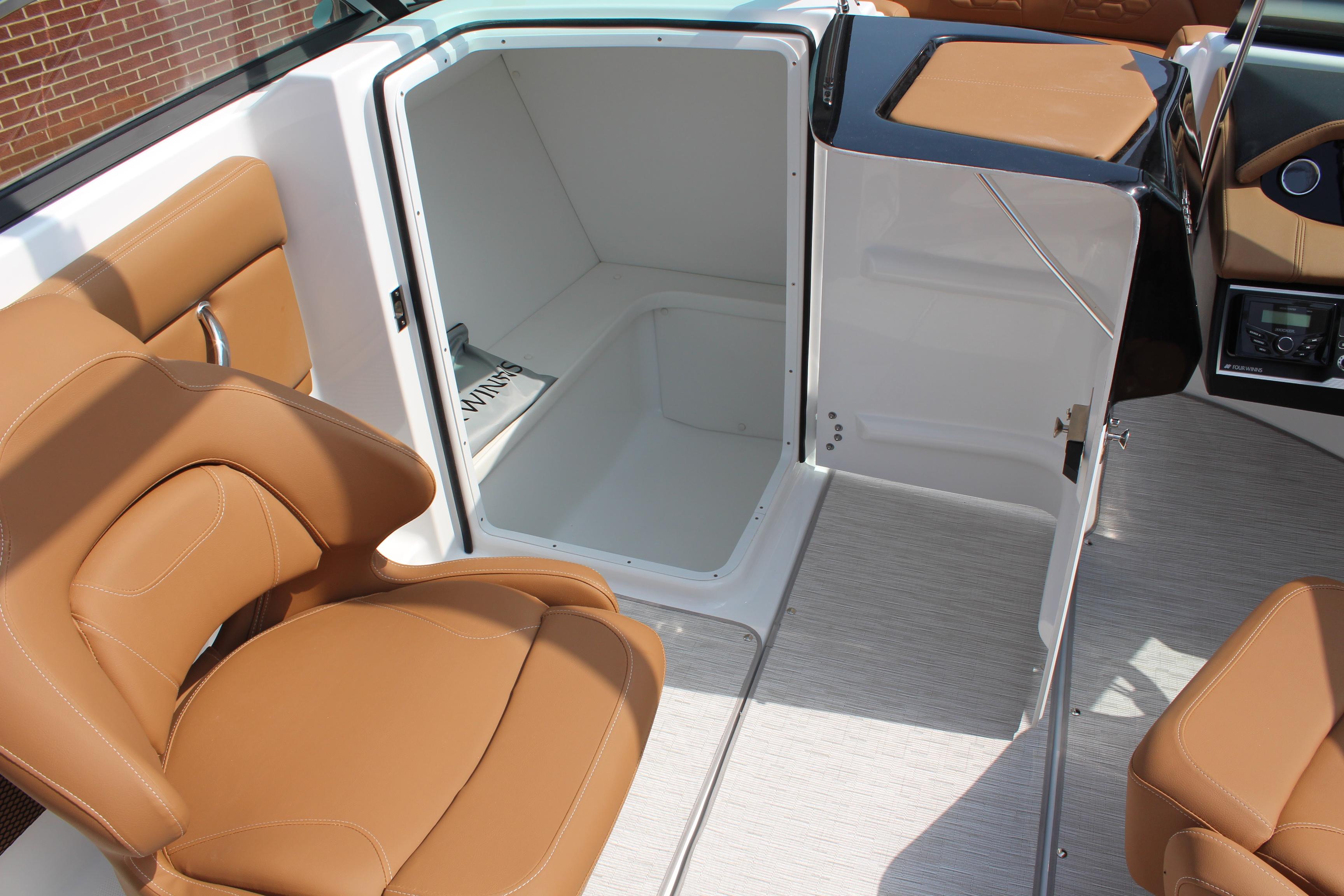 2025 Four Winns HD3 OB boat interior with tan seating and storage compartment.