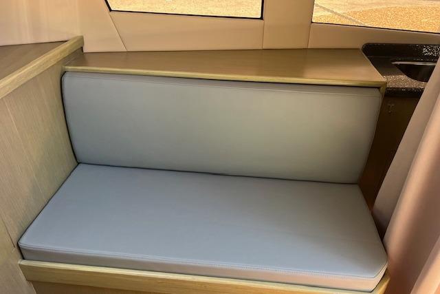 2024 Bracewell 25 interior seating with light gray cushion and wooden accents.