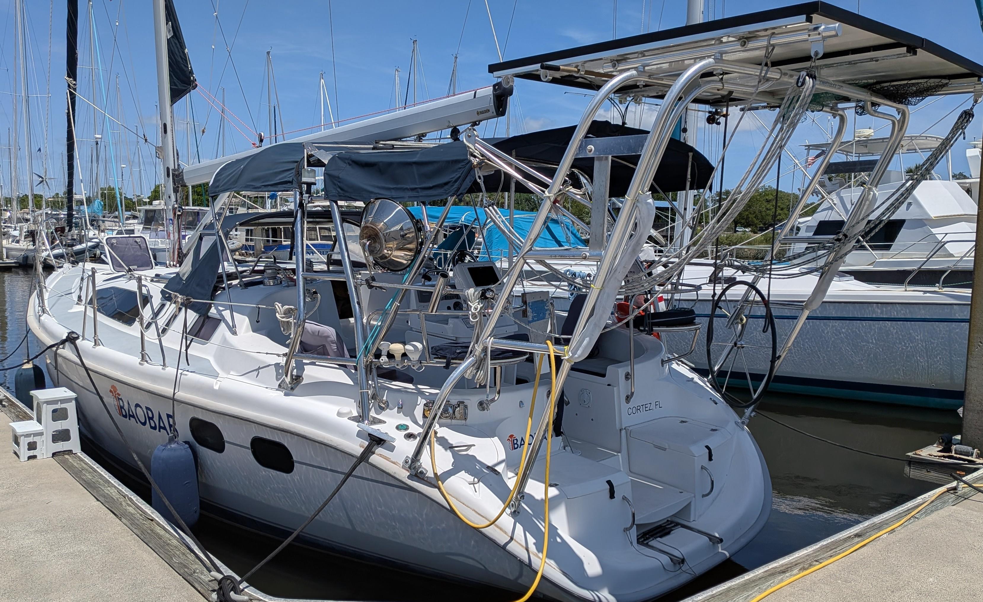 2001 Hunter 380 sailboat docked at marina, featuring solar panels and nautical equipment.
