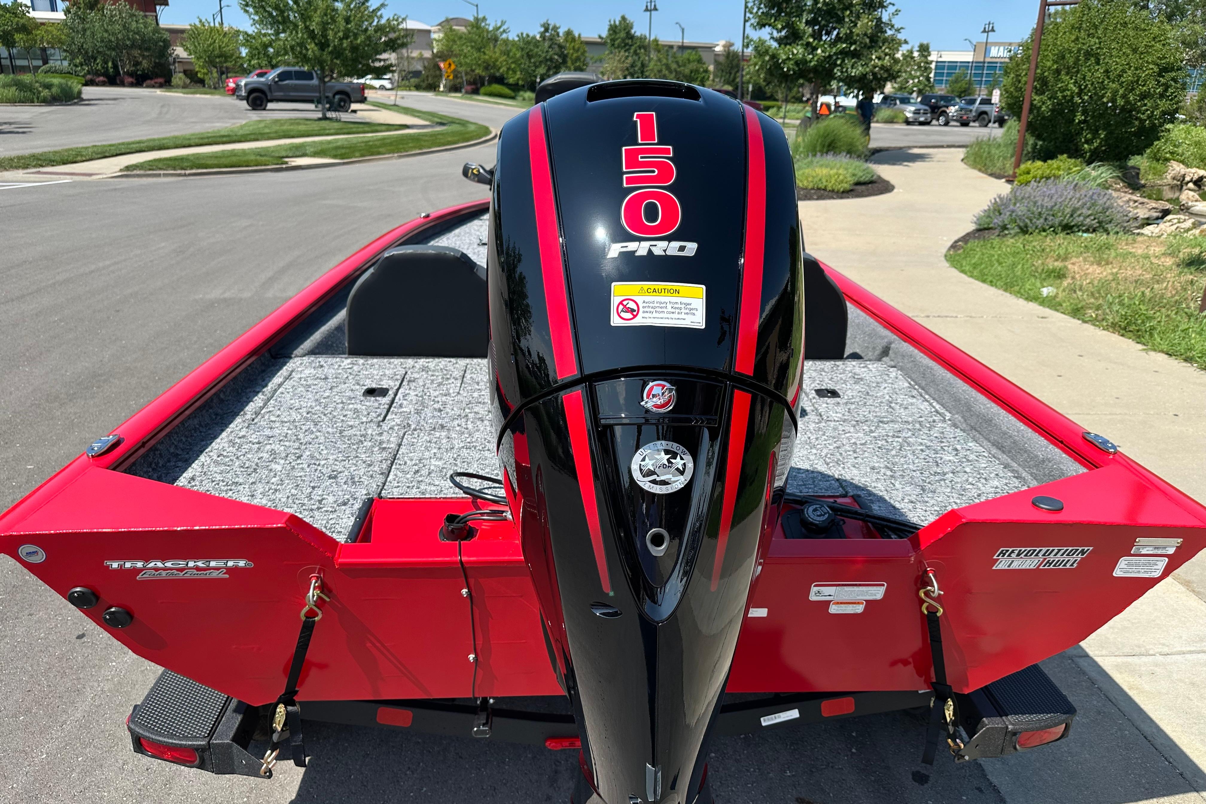 2026 Tracker Pro Team 195 boat with 150 Pro engine, parked on a sunny street.