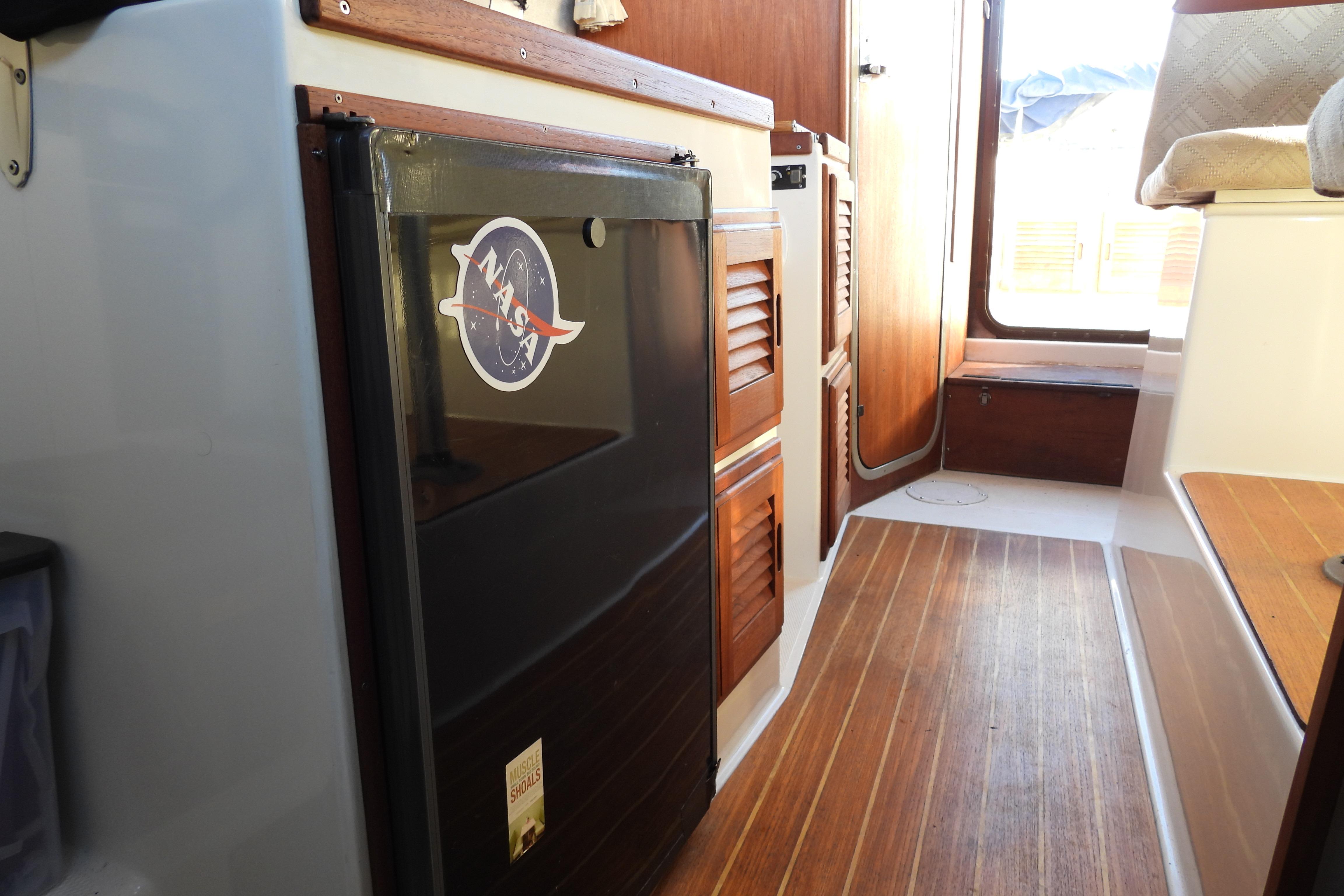 Interior of a 2007 Ranger Tug R-25 boat with wood flooring and cabinetry.