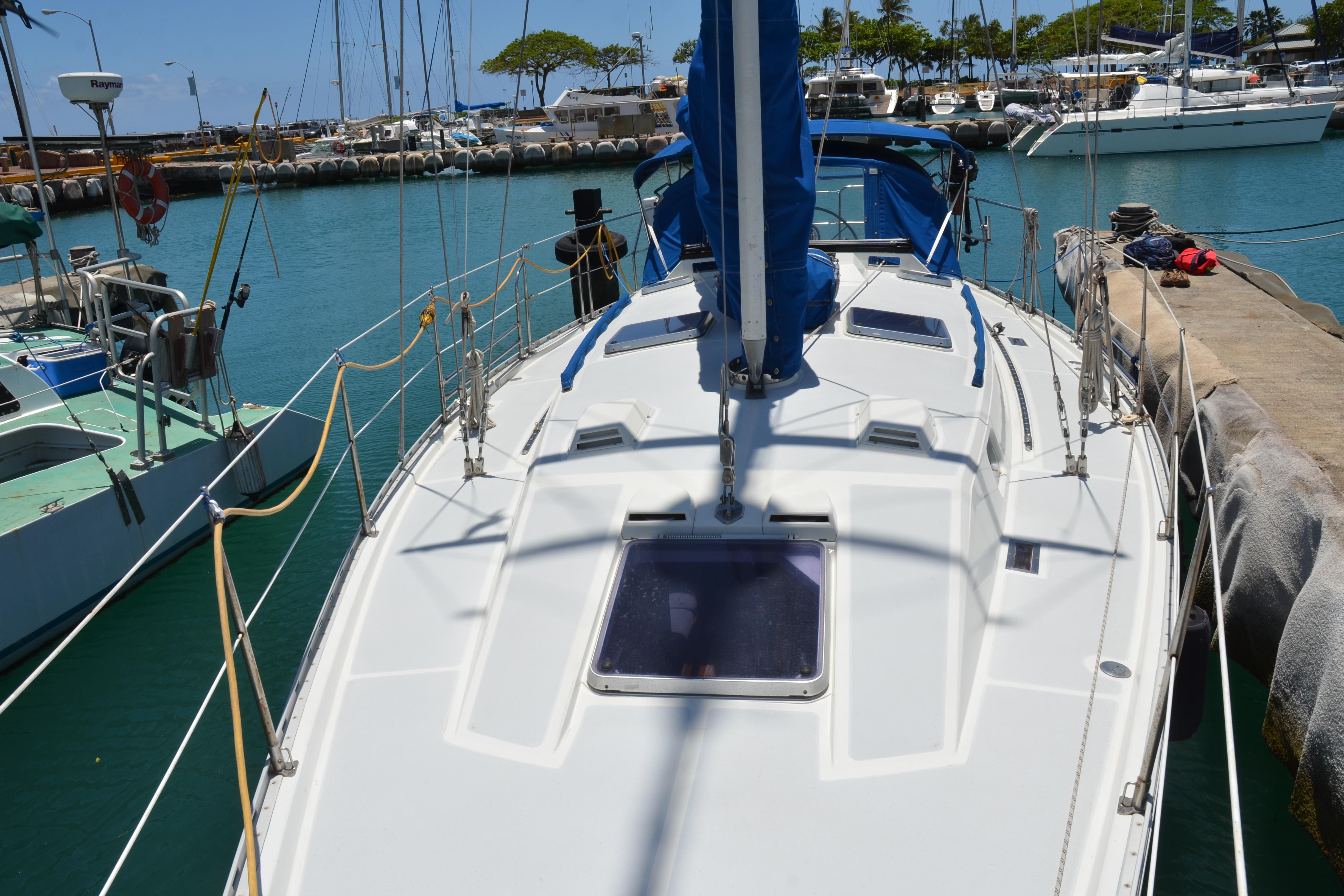 1987 Norseman 400 sailboat docked in a sunny marina, surrounded by other boats.