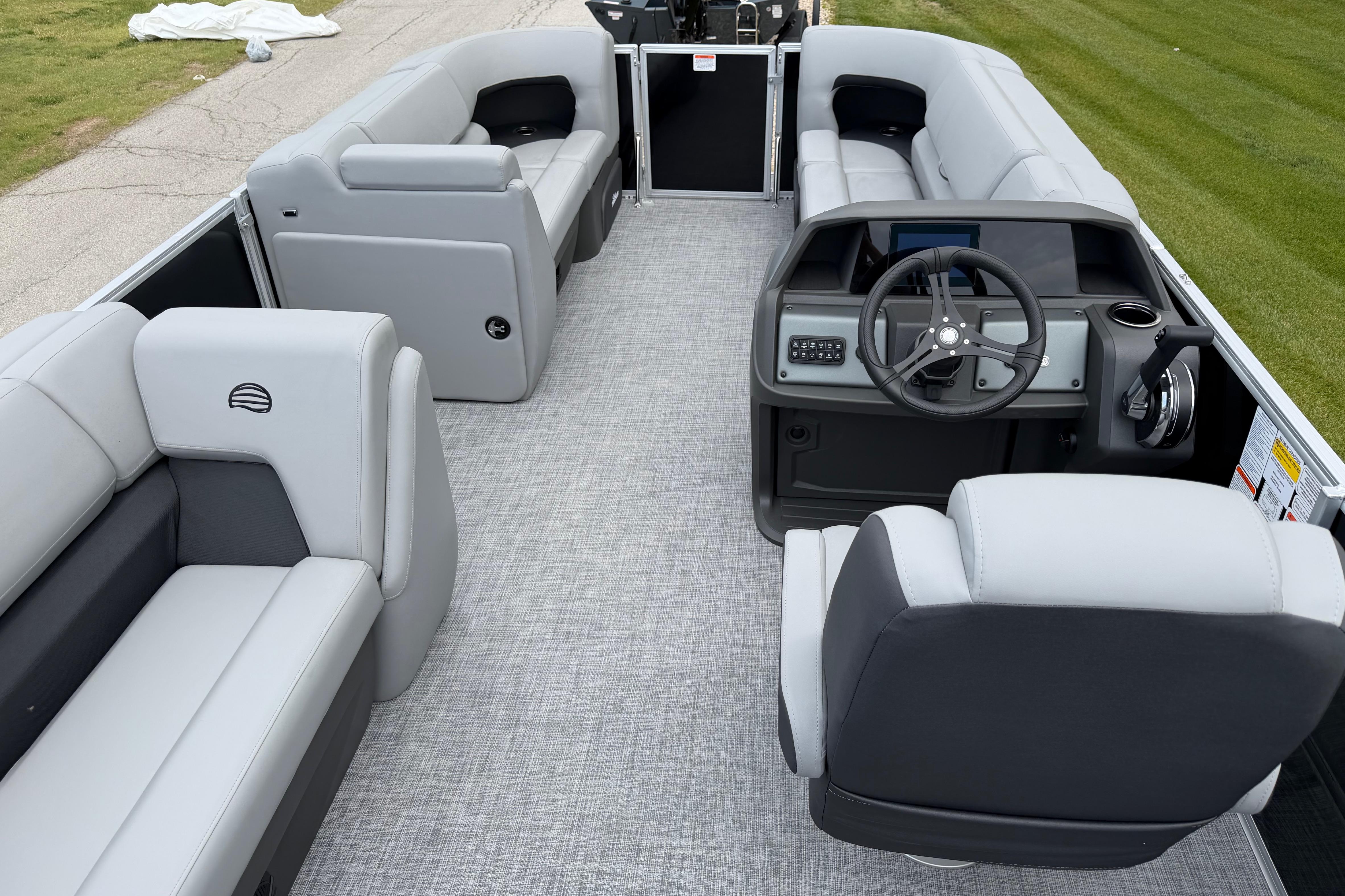 2026 Sun Tracker Party Barge 20 DLX interior with gray seating and steering console.