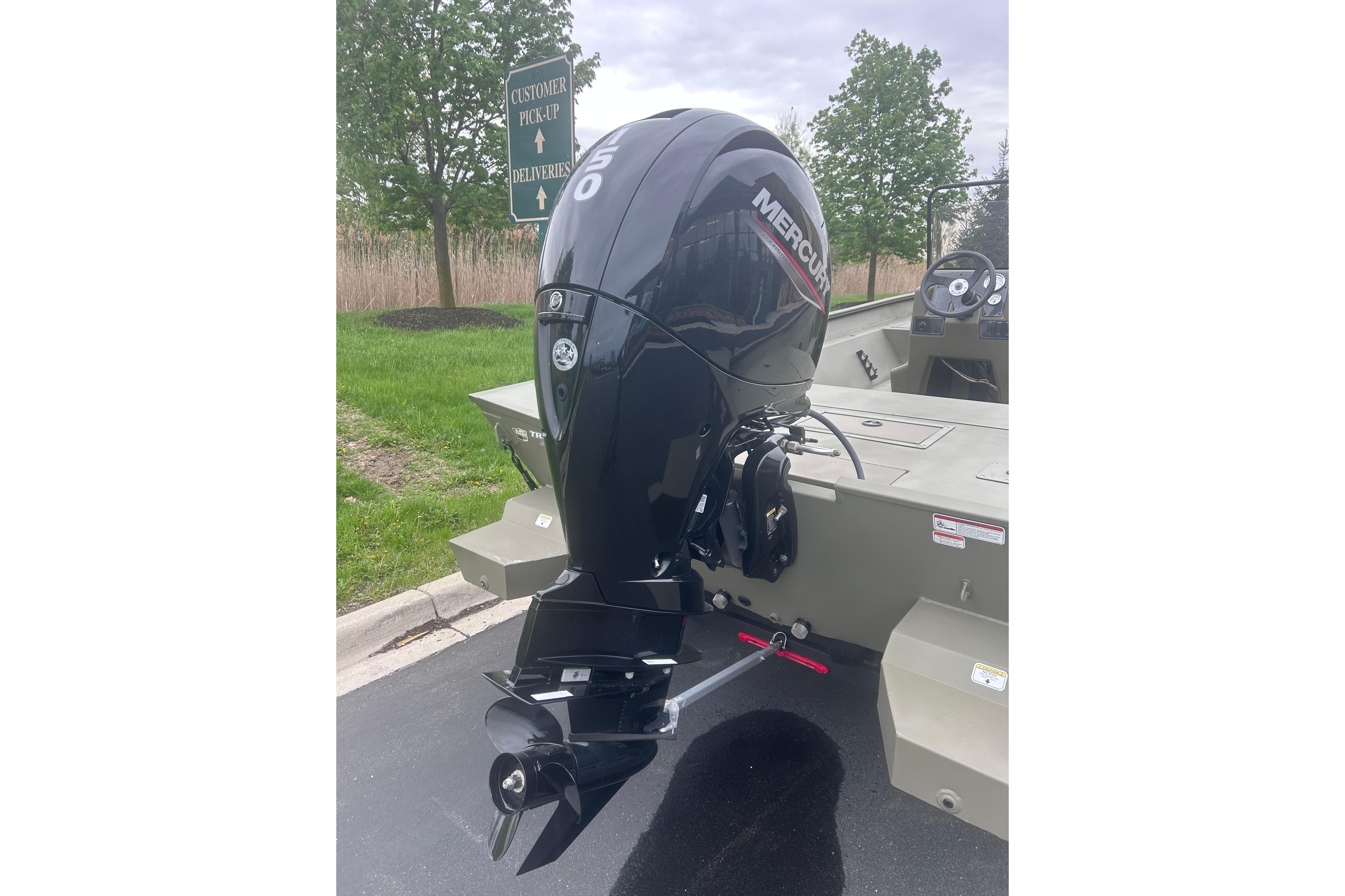 2024 Tracker Grizzly 2072 CC boat with Mercury outboard motor in parking lot.