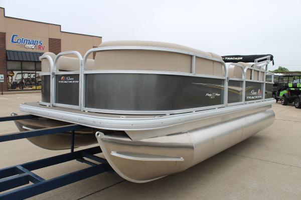2025 Sun Tracker Party Barge 18 DLX pontoon boat on trailer at dealership.