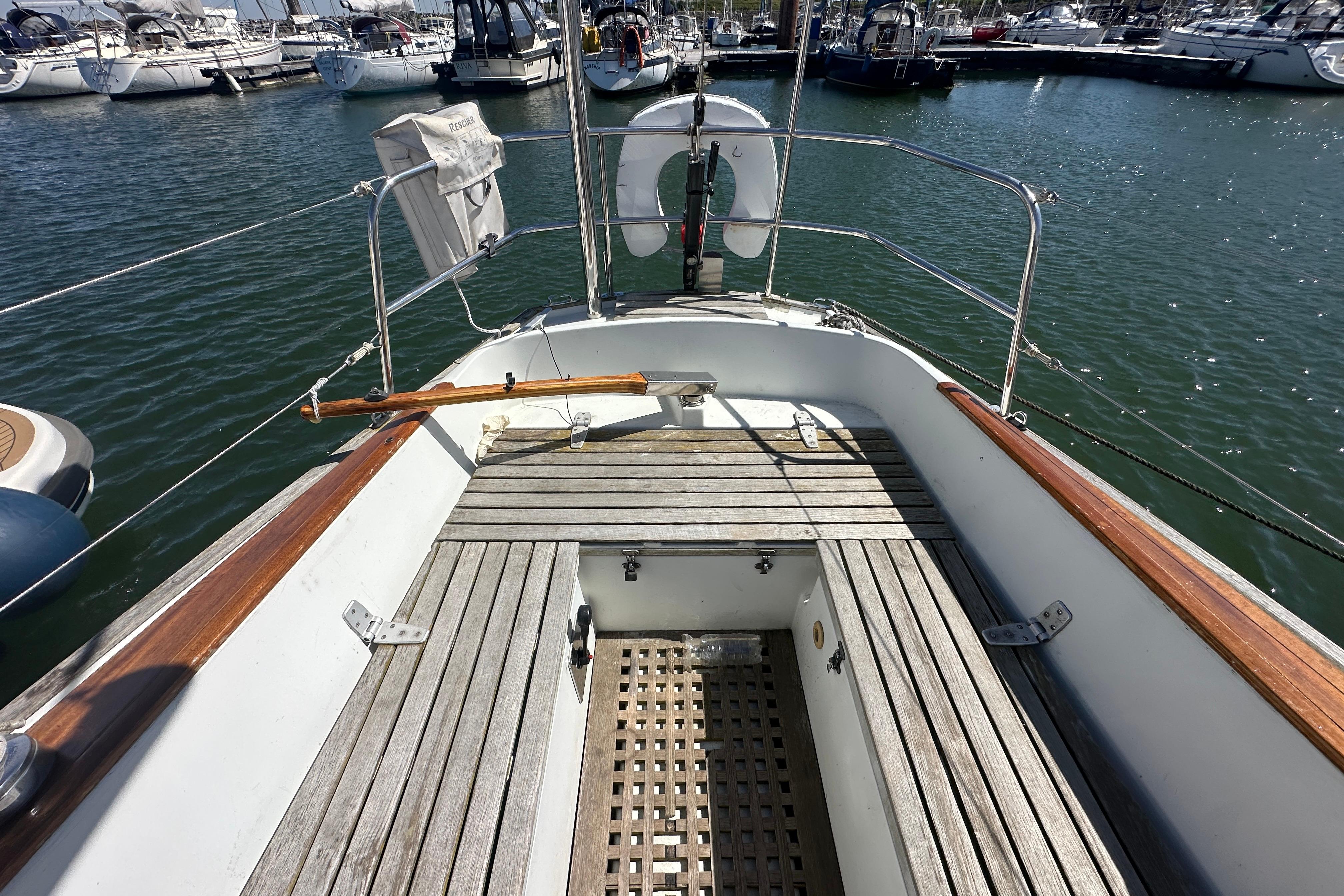 1973 Wauquiez Centurion 32 sailboat cockpit with wooden seating, docked in a marina.