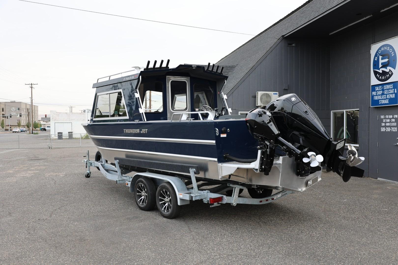 2026 Thunder Jet 24 Alexis Pro boat on trailer outside marine shop.