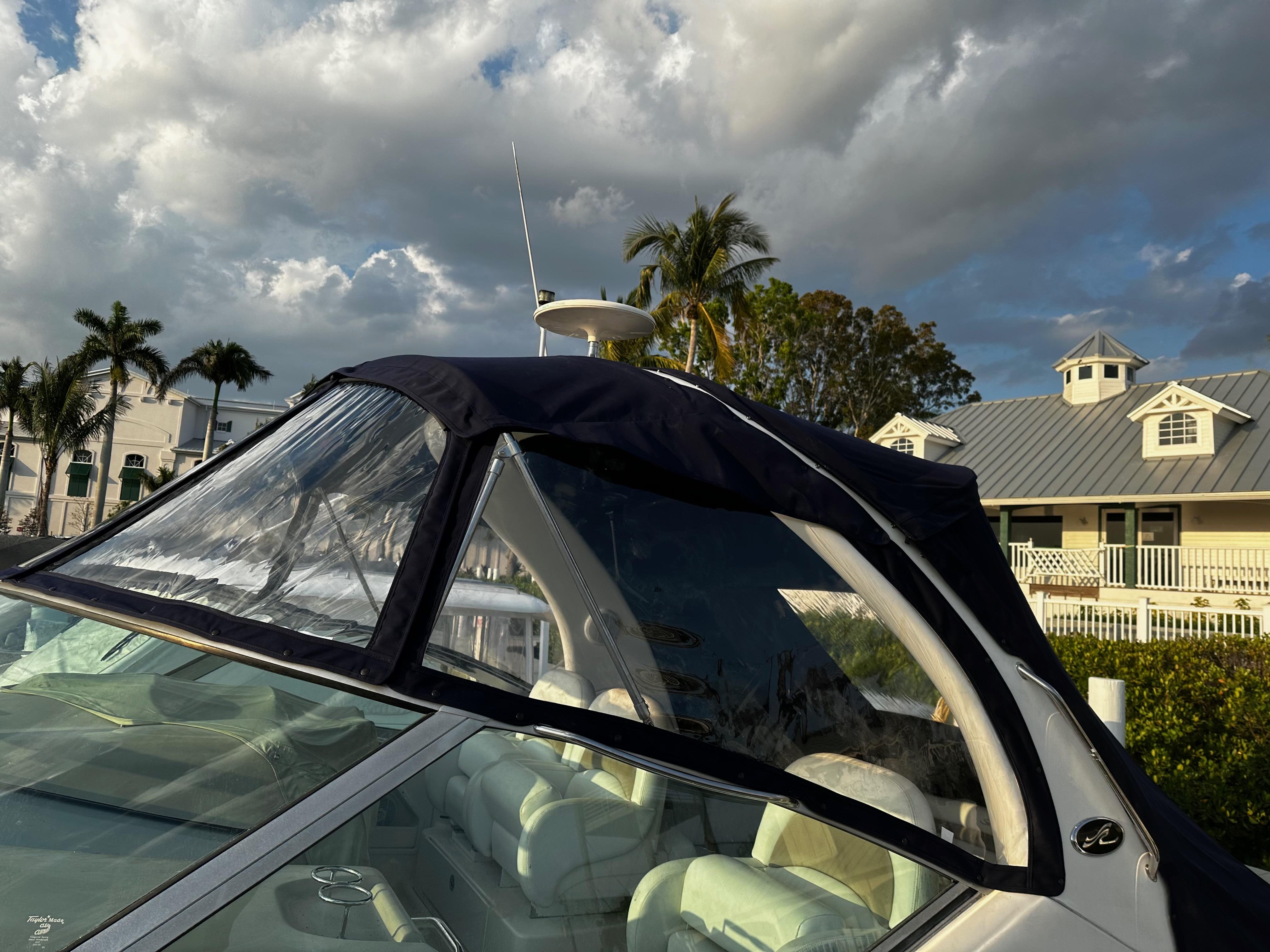 2005 Sea Ray 340 Sundancer boat with canopy, set against a tropical backdrop.