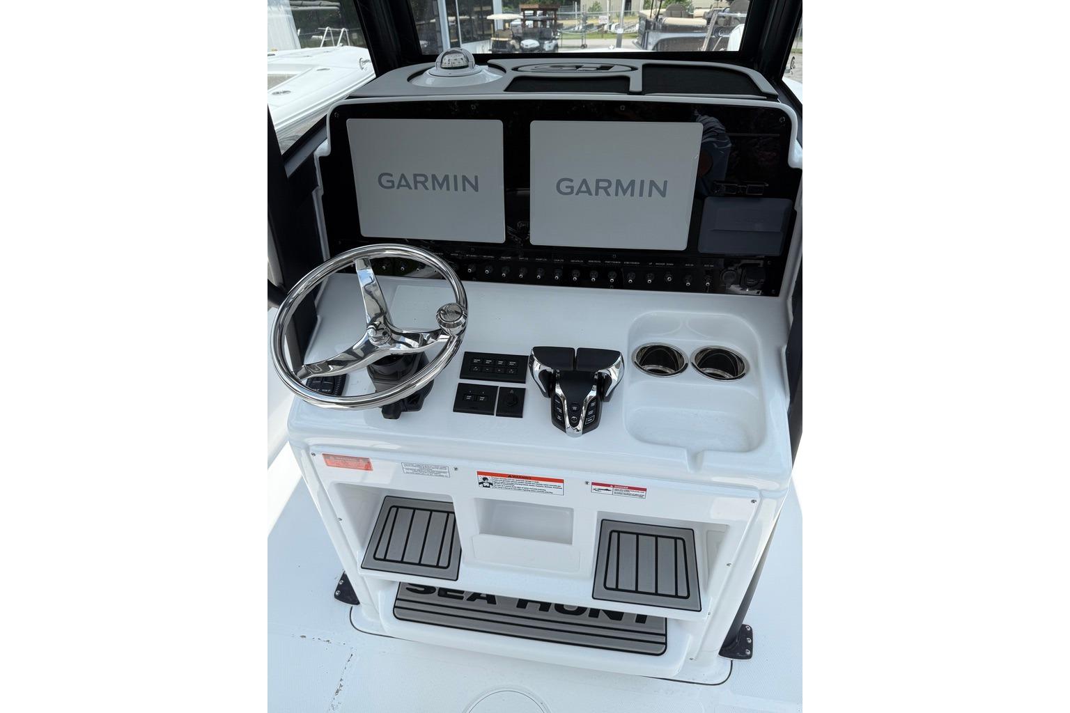 2026 Sea Hunt Gamefish 27 Coffin Box helm with Garmin displays and steering wheel.