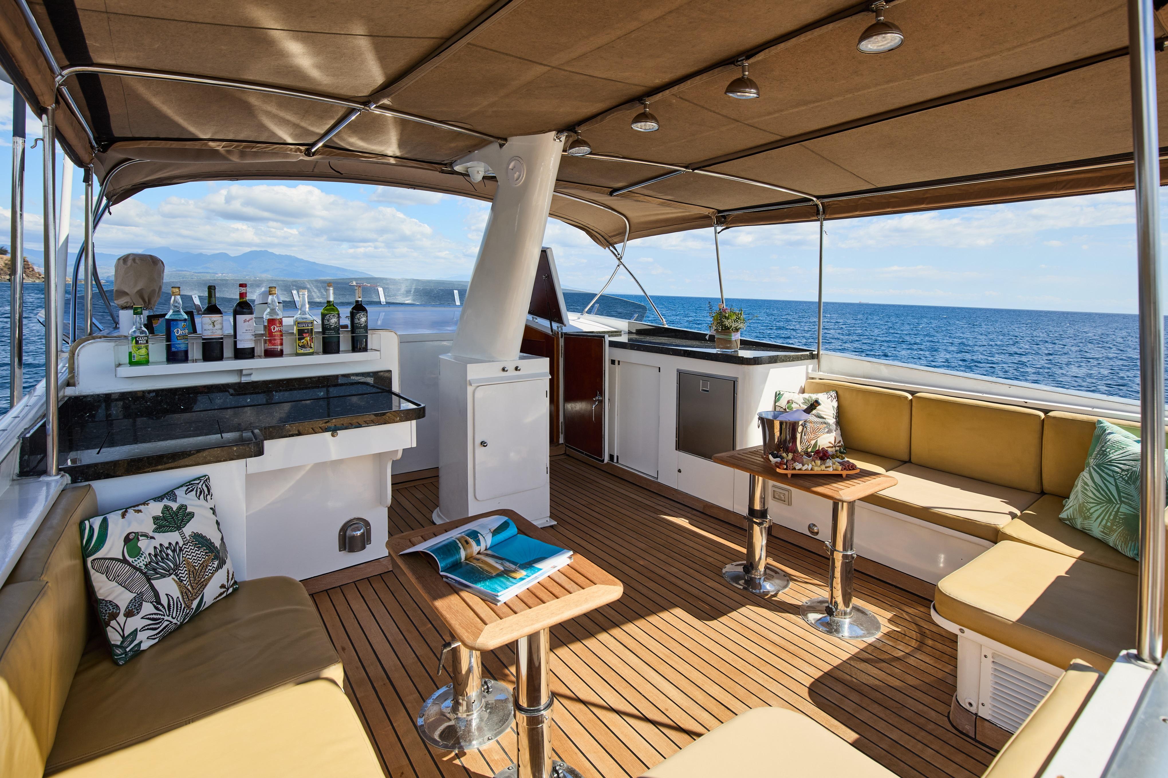 Luxurious 1973 Benetti 26D yacht deck with bar, seating, and ocean view.