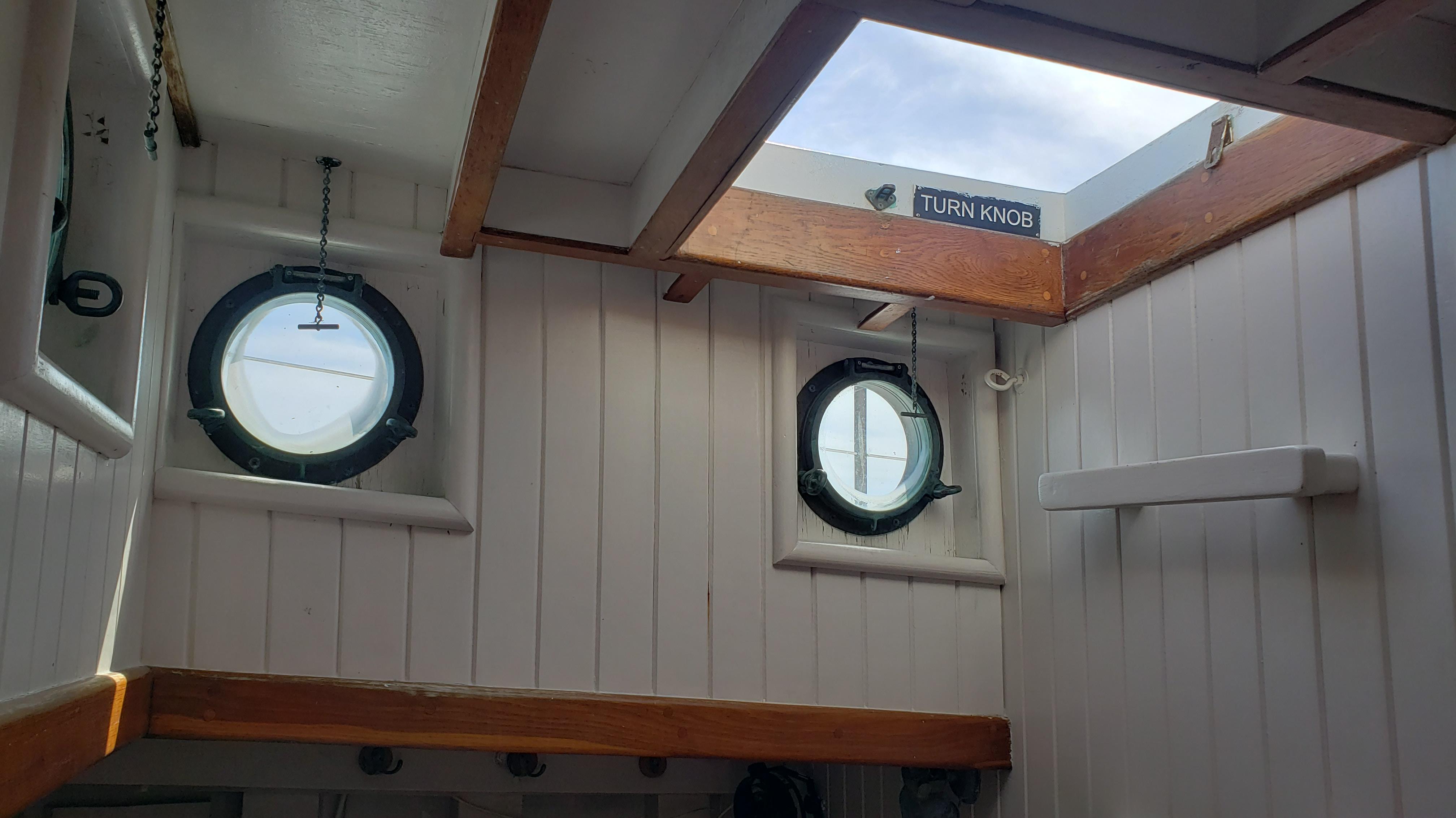 Interior of 1996 Custom Biloxi Schooner with portholes and wooden beams.