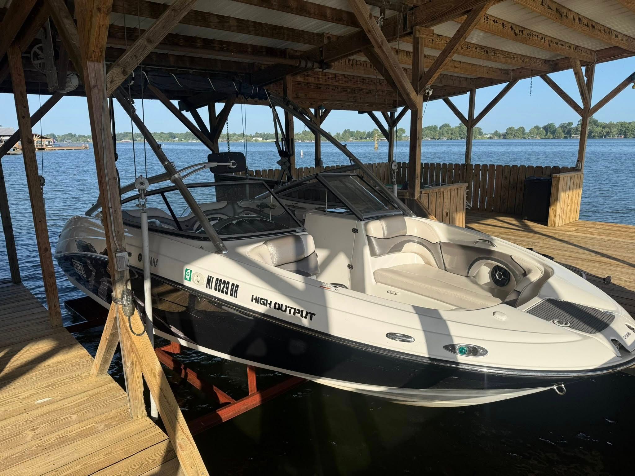 2008 Yamaha Boats 212X under a wooden dock by the lake.