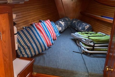 1990 Morgan 44 Centre Cockpit interior with cozy bedding and striped pillows.
