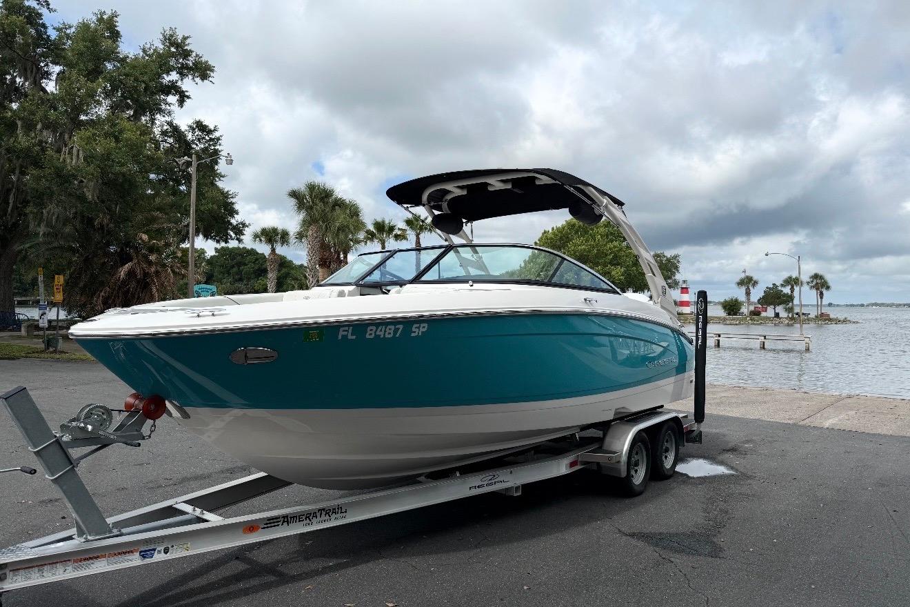 2020 Regal LX4 boat on trailer near waterfront, under cloudy sky.