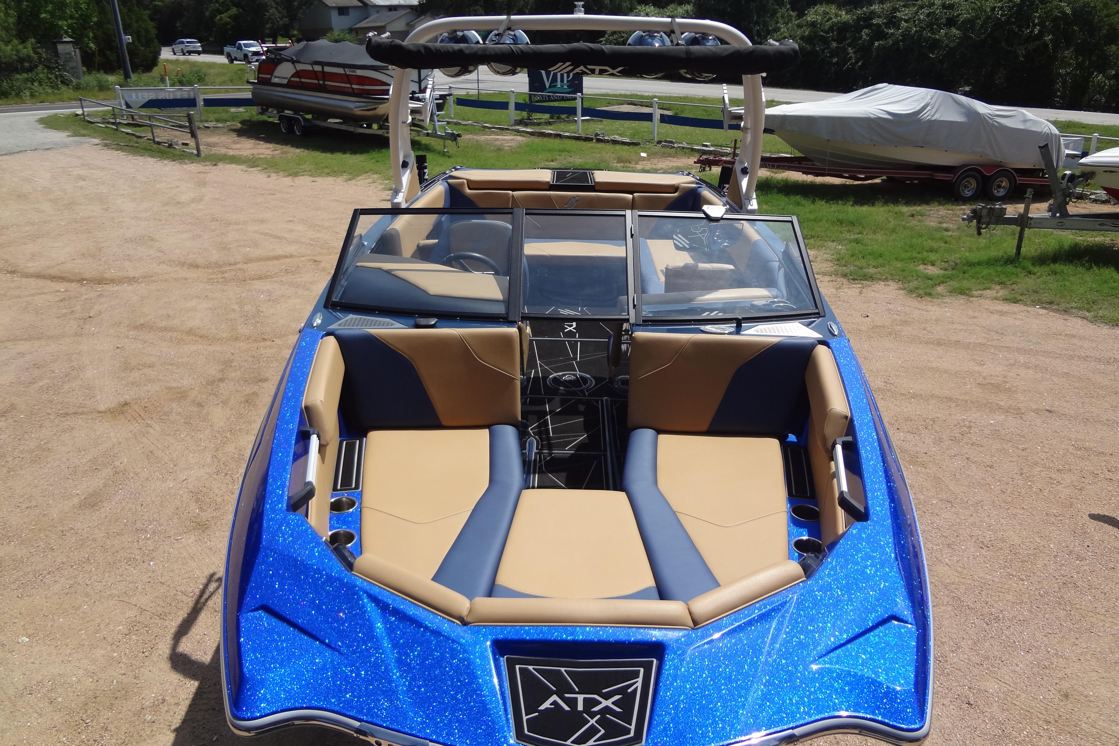 2022 ATX Surf Boats 24 Type-S, blue exterior, tan interior, parked on sandy ground.