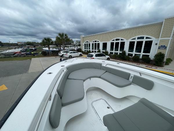 2026 Cape Horn 24XS boat with spacious seating, parked near a building under cloudy skies.