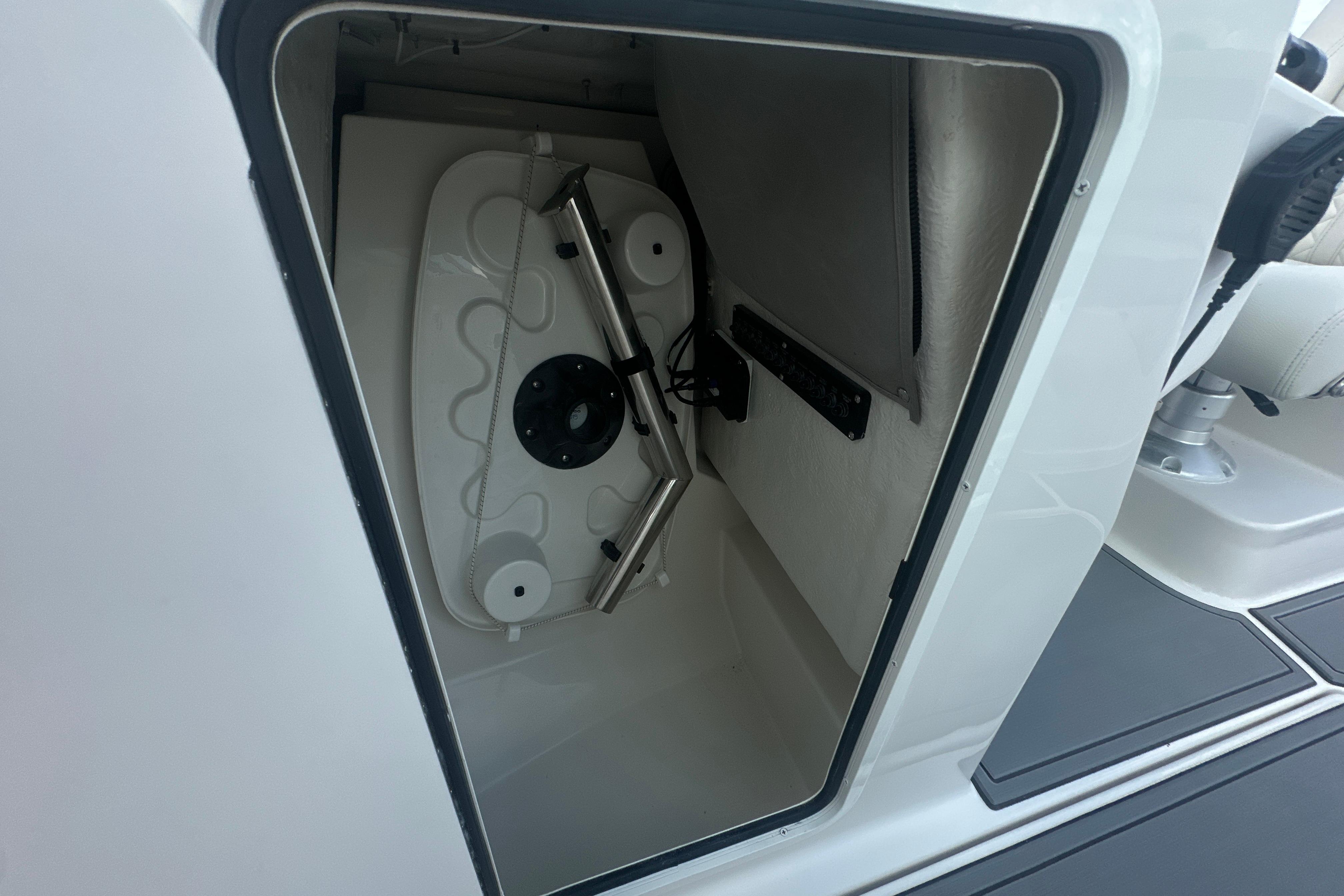 Open storage compartment on 2026 Sailfish 226 DC boat, showcasing interior details.