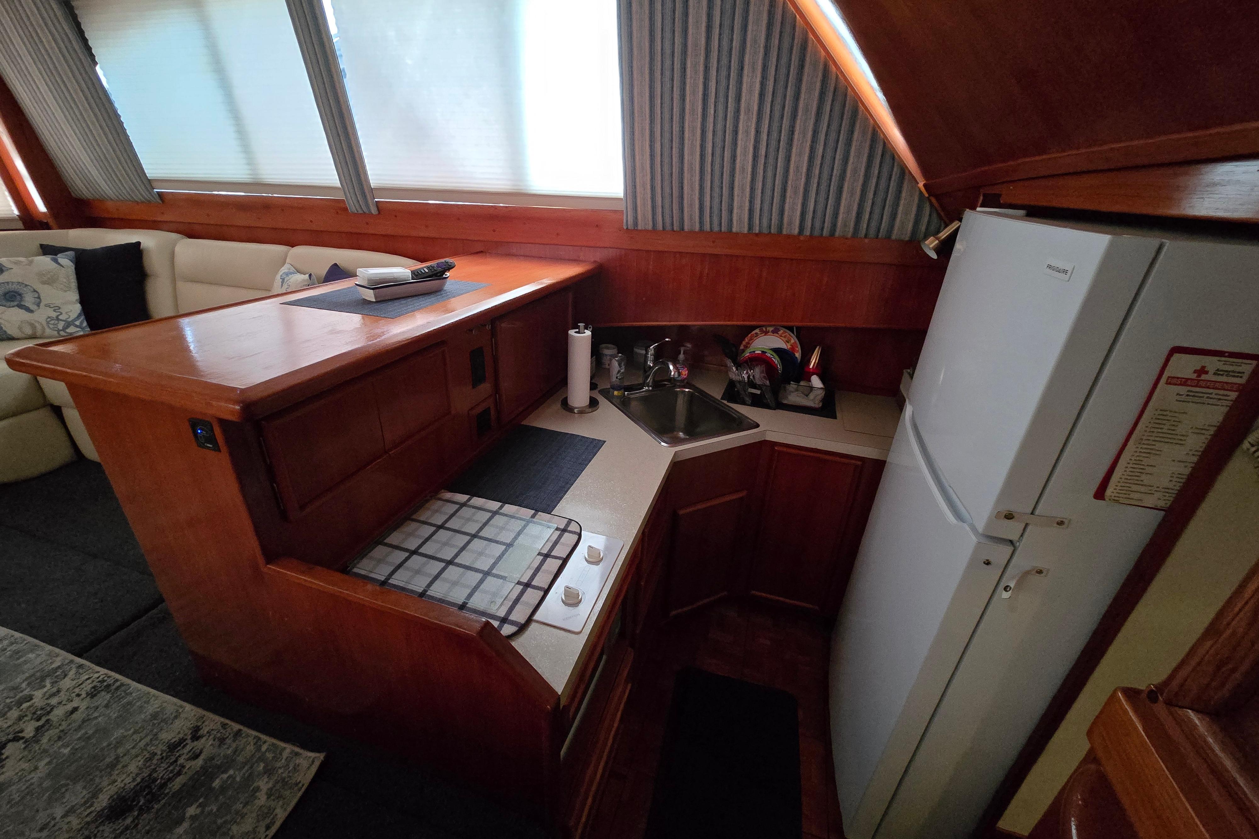 1988 Post 46 Convertible yacht interior kitchen with wooden cabinetry and modern appliances.