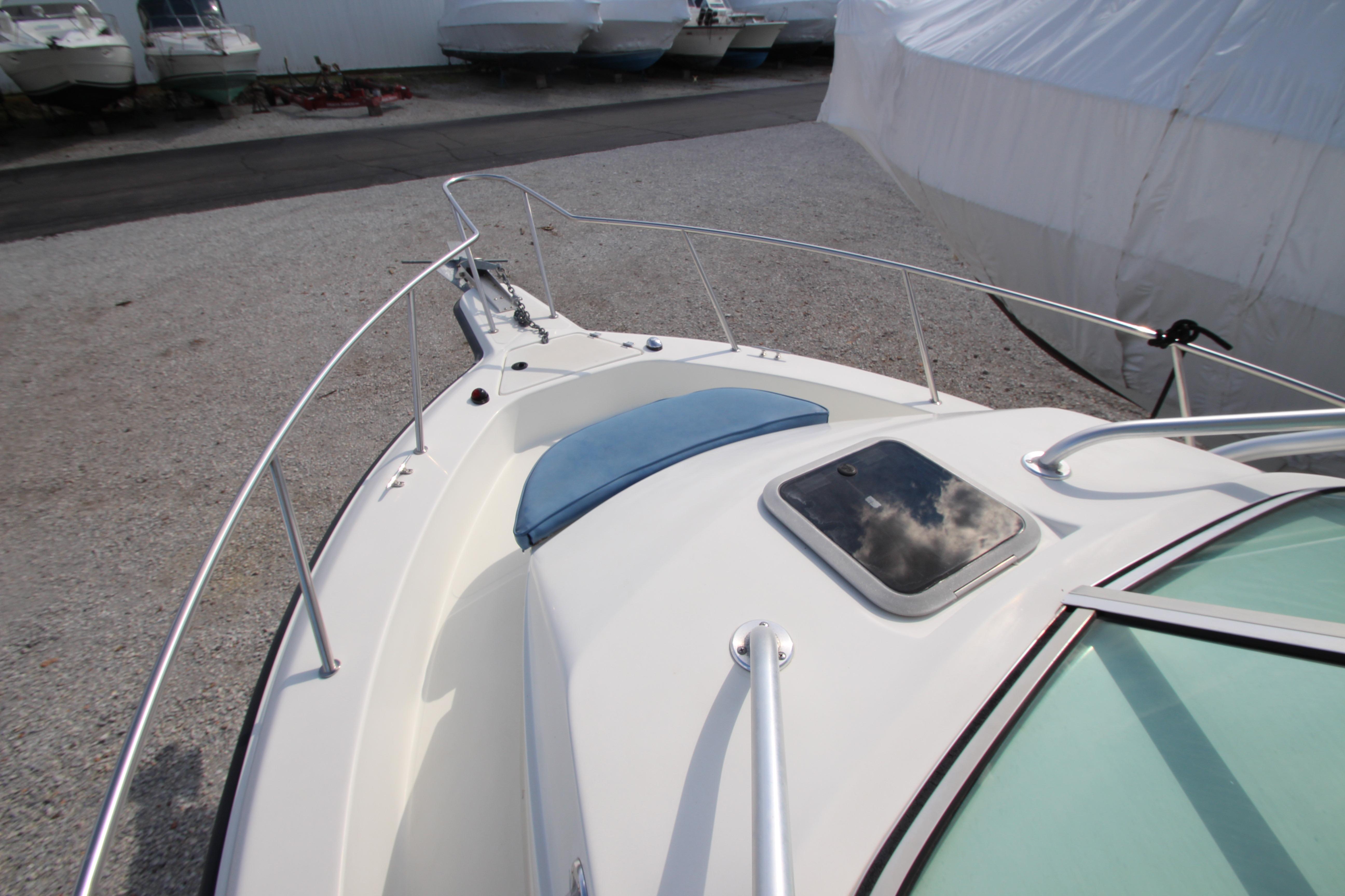 2002 Hydra-Sports 230 WA boat deck with railing and hatch, parked on gravel.