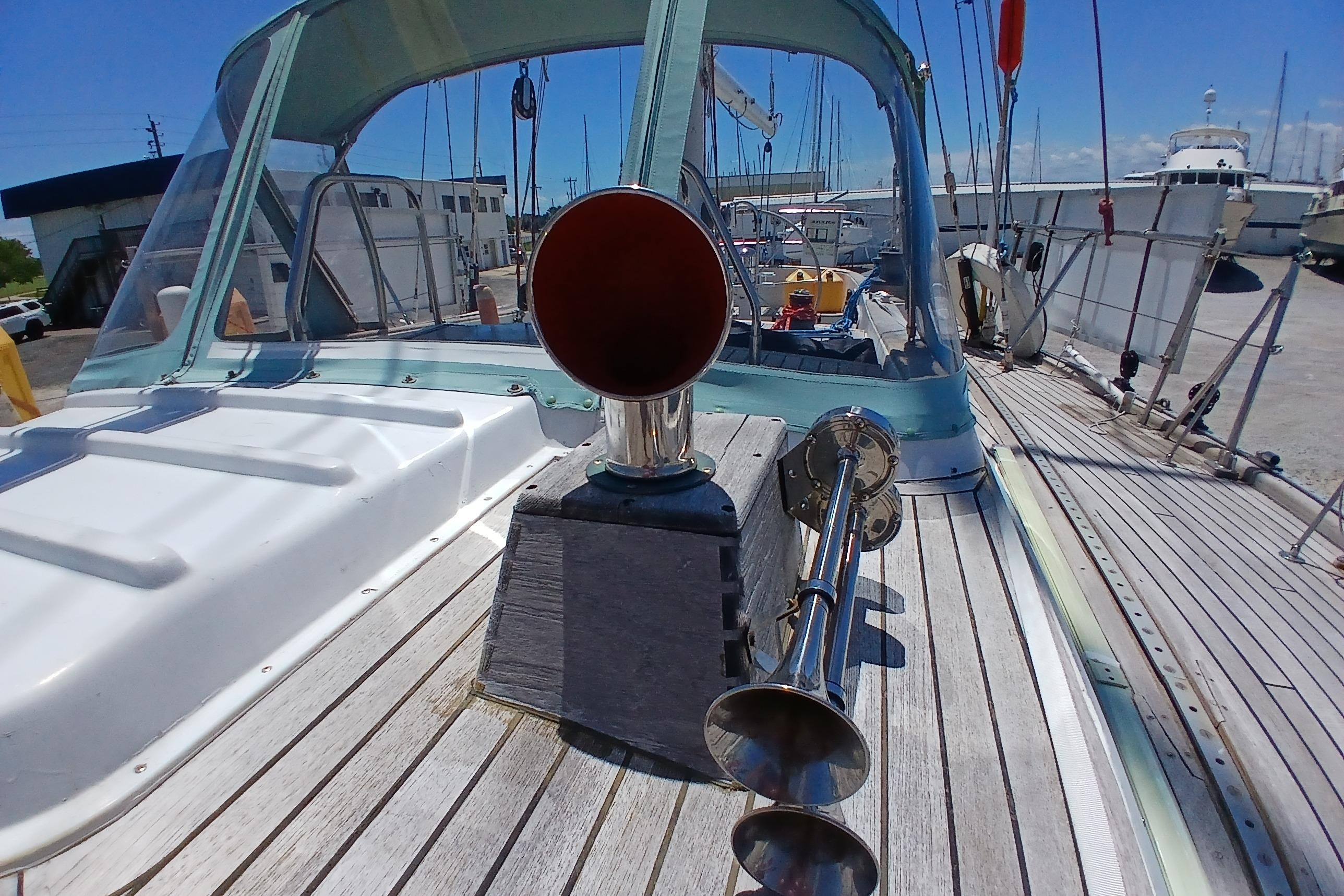 1981 Kaufman Skye 51 sailboat deck with horn and canopy in marina setting.