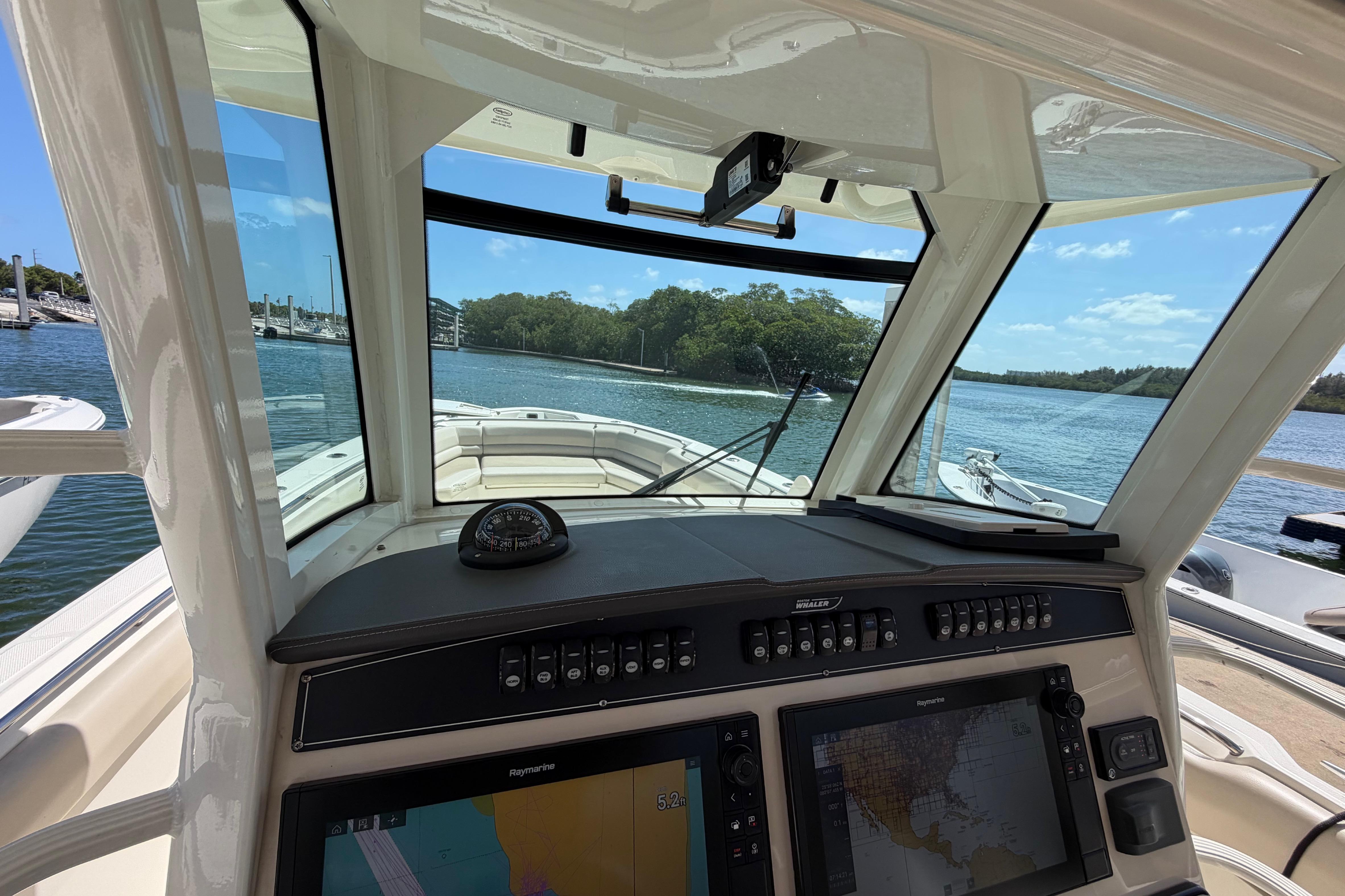2019 Boston Whaler 330 Outrage helm with navigation screens and scenic water view.