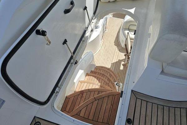 Interior view of 2005 Sunseeker Manhattan 66 yacht with wooden stairs and seating area.