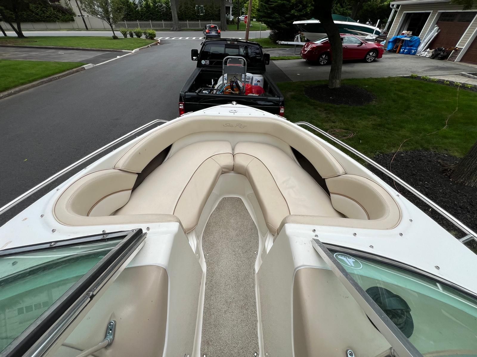 A 1997 Sea Ray 190 Bow Rider with beige seating, parked on a trailer.