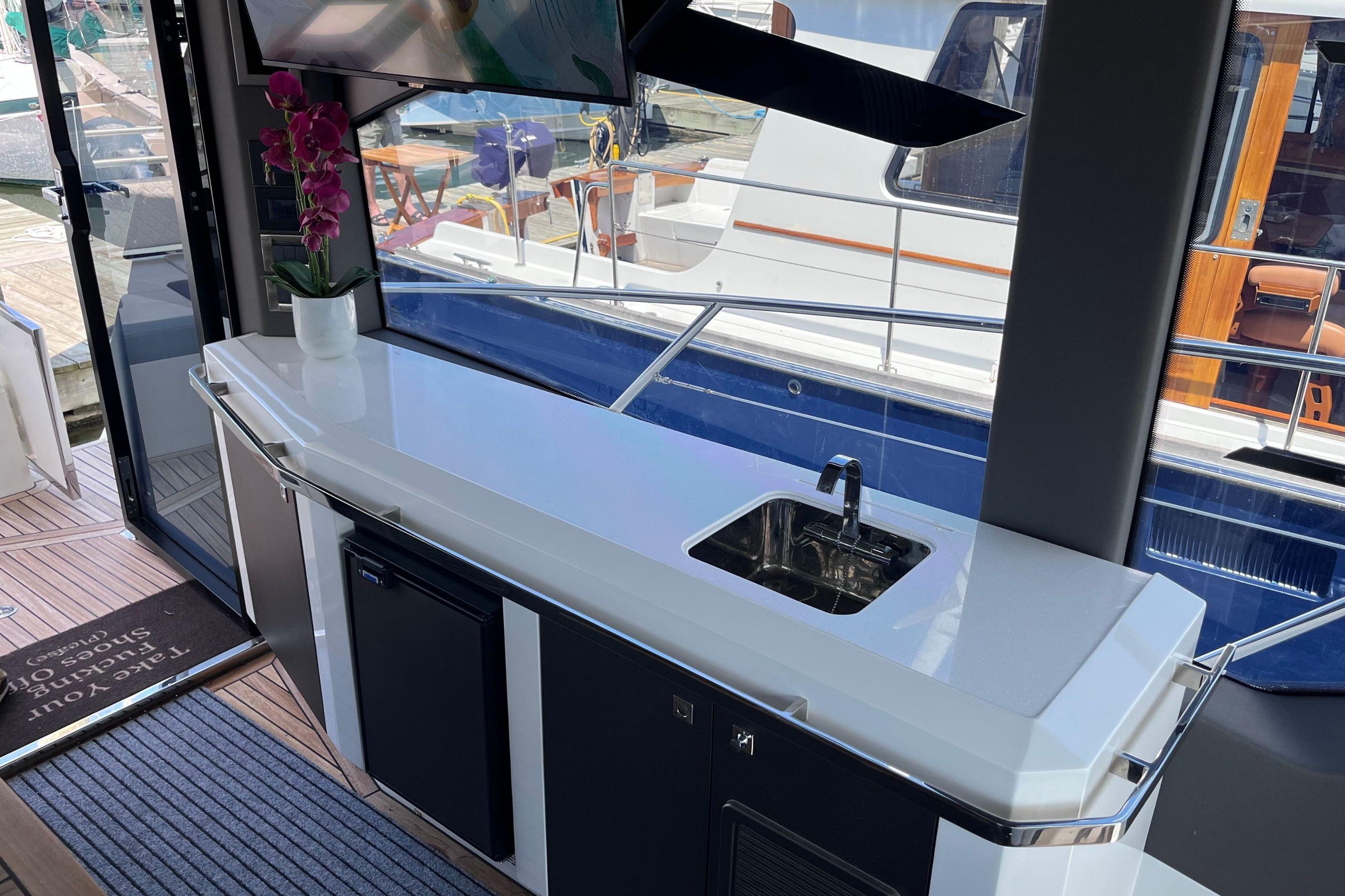 Luxurious interior of 2024 Galeon 425 HTS yacht with sleek kitchenette and modern amenities.