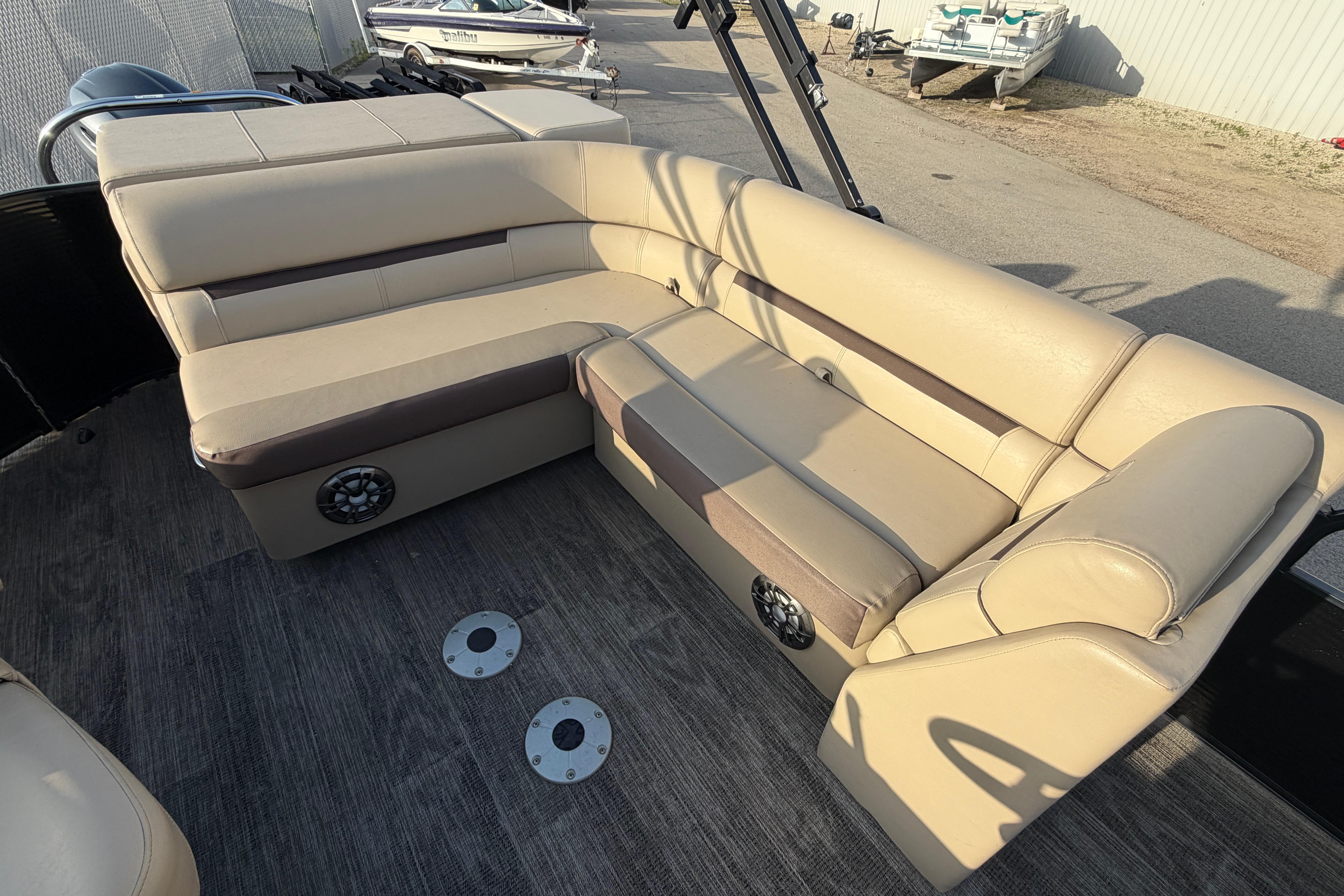 2023 Godfrey Sweetwater 2286 C boat interior with beige seating and speakers.