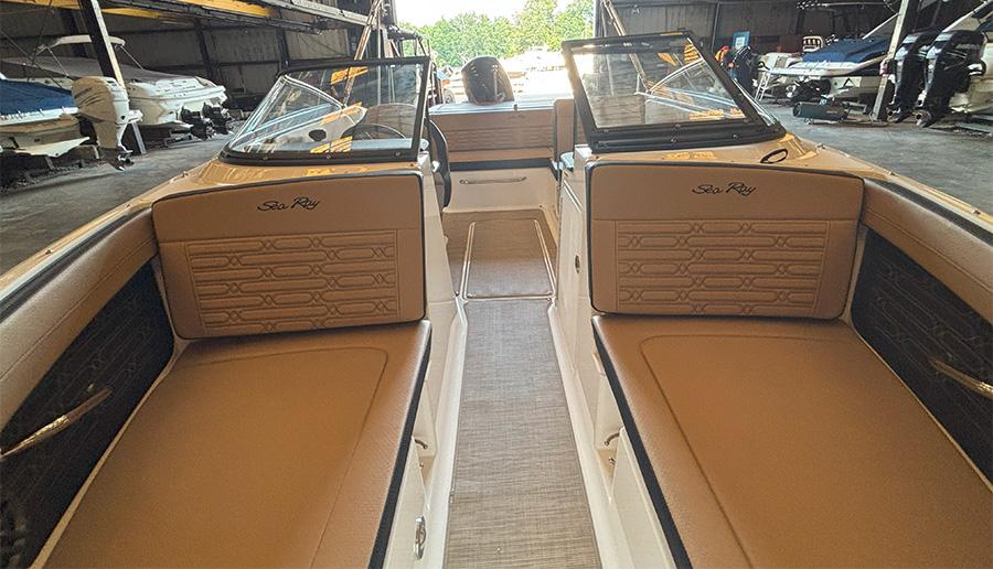 2025 Sea Ray SPX 190 Outboard interior with tan seating in a boat storage facility.