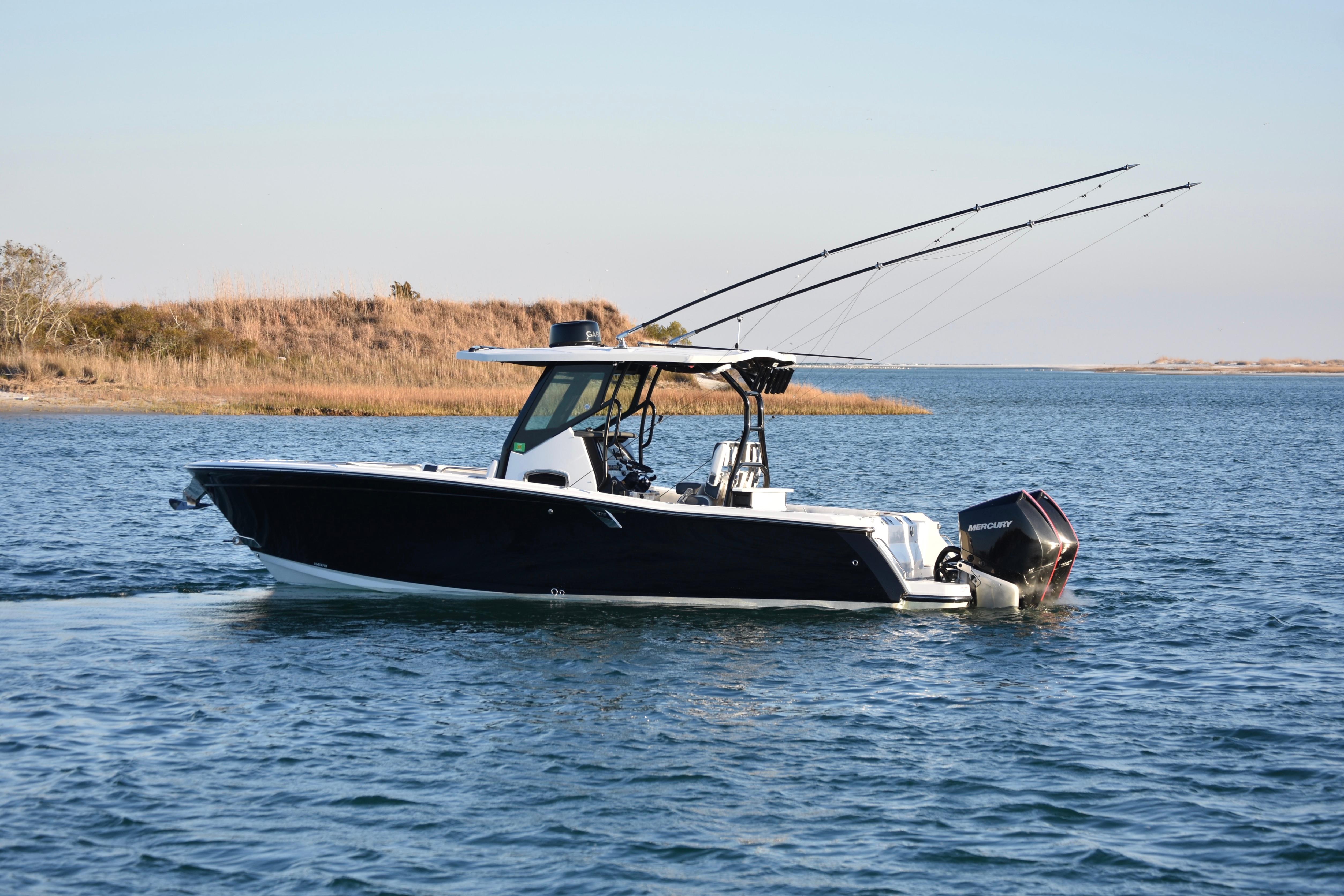 2022 Blackfin 272 CC boat cruising on a calm lake with fishing rods.