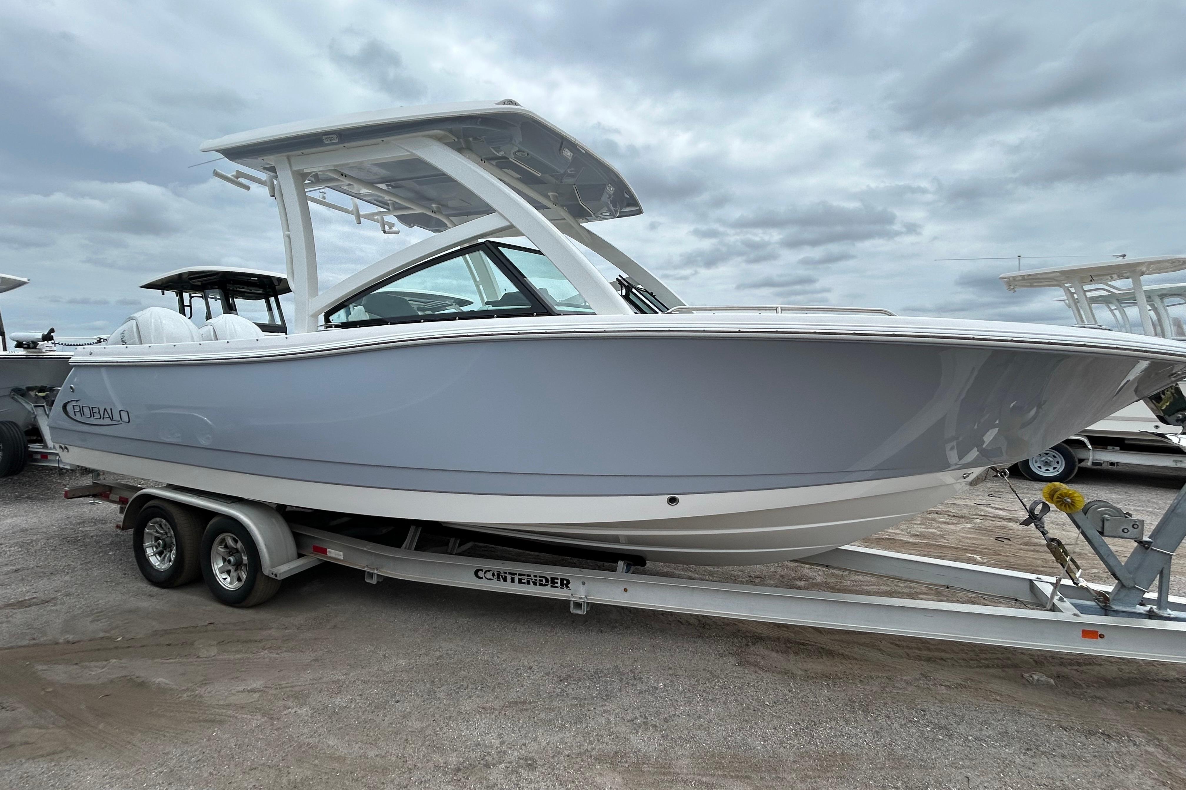 2026 Robalo R277 Dual Console boat on trailer under cloudy sky.